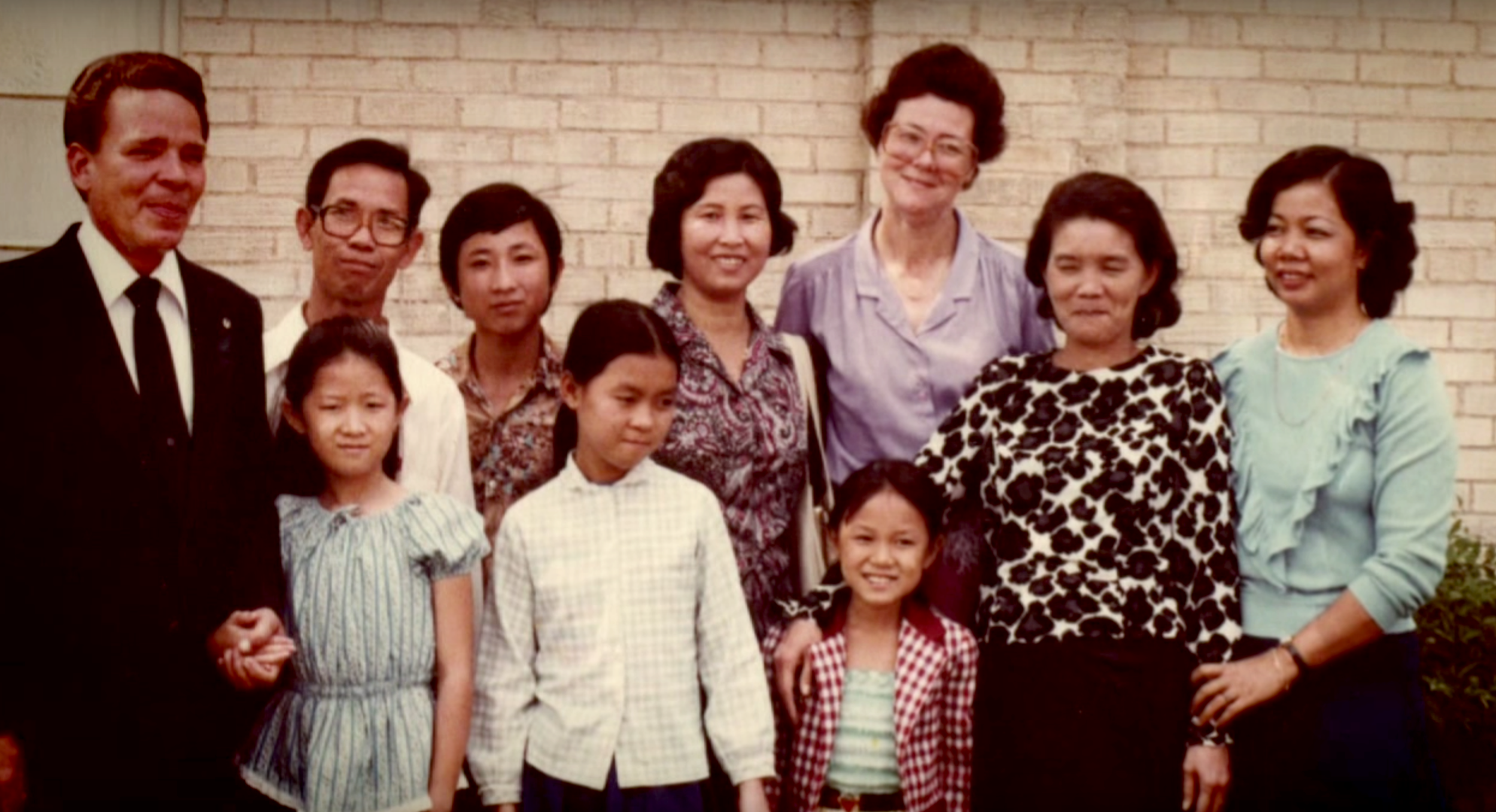 Thear (bottom center) with her family and Catholic Refugee Services staff, shortly after arriving in the United States.
