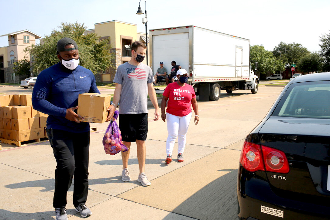 Darrion and his team help load groceries into a waiting car during a neighborhood food distribution.
