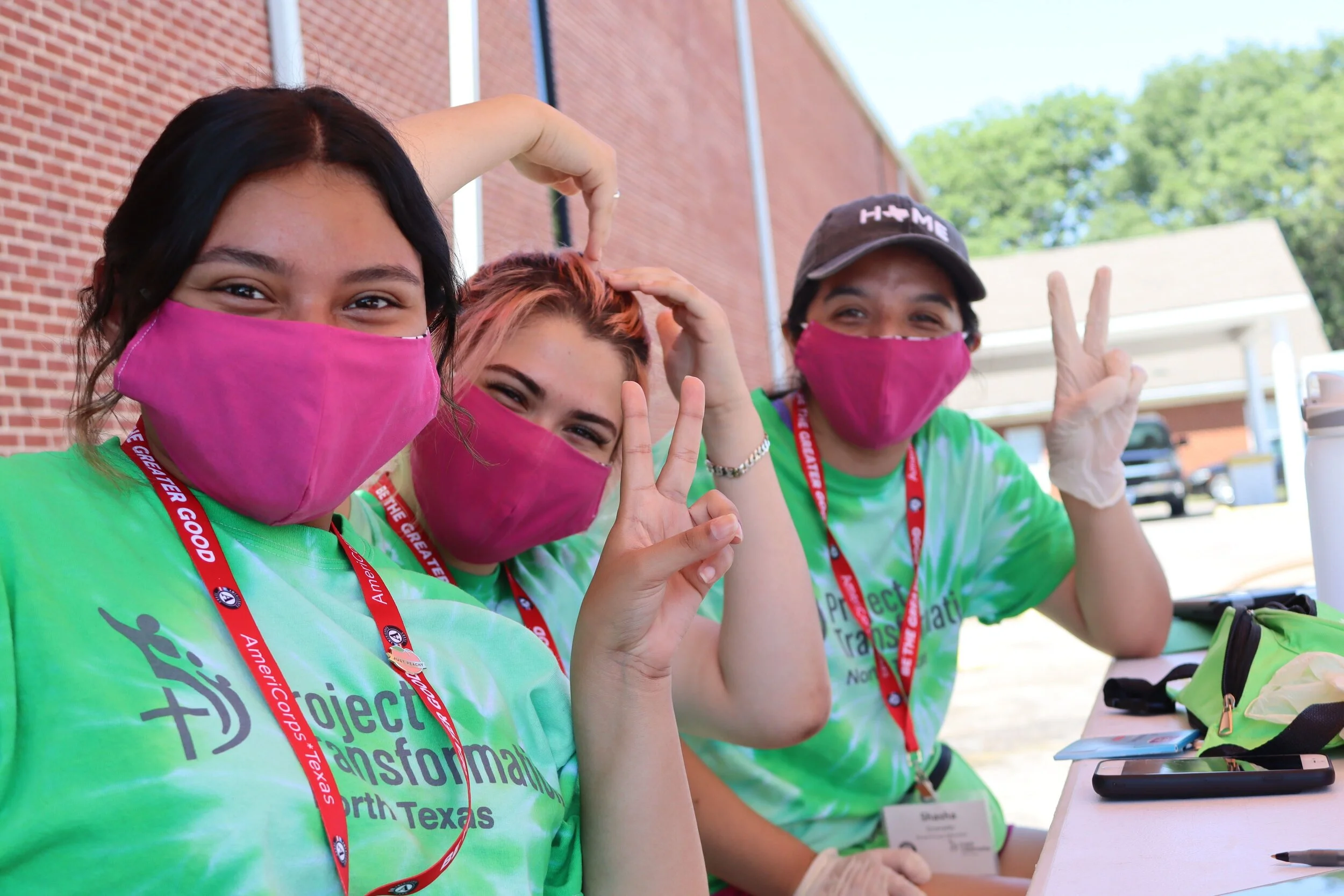 Young adult volunteers at a at a Project Transformation North Texas site location distributing food and household supplies to families.