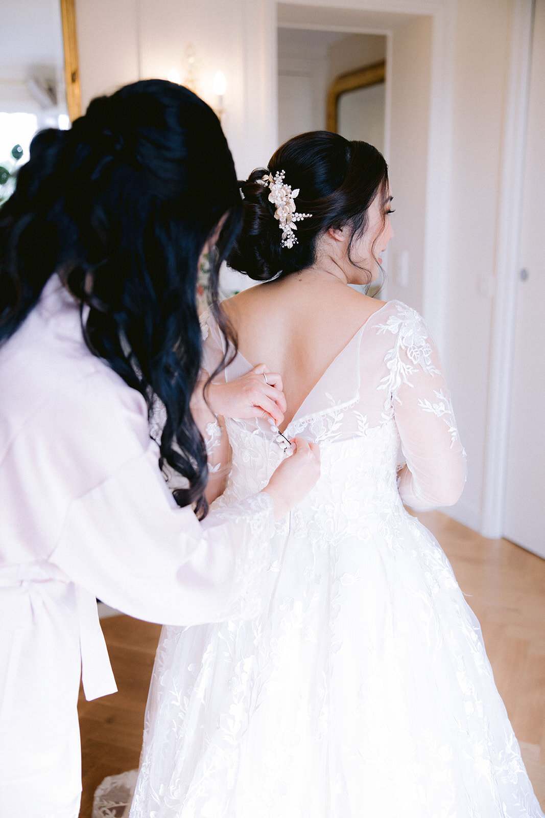  Linda, being helped into her wedding gown by her bridesmaid at her 7th Arrondissement Paris Airbnb. 