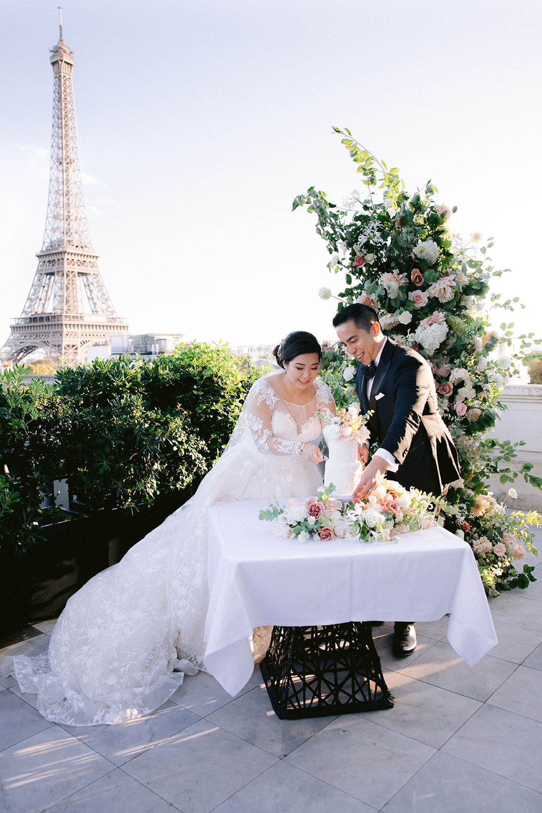  Bride and Groom cutting the cake for their chic Paris rooftop destination wedding. 