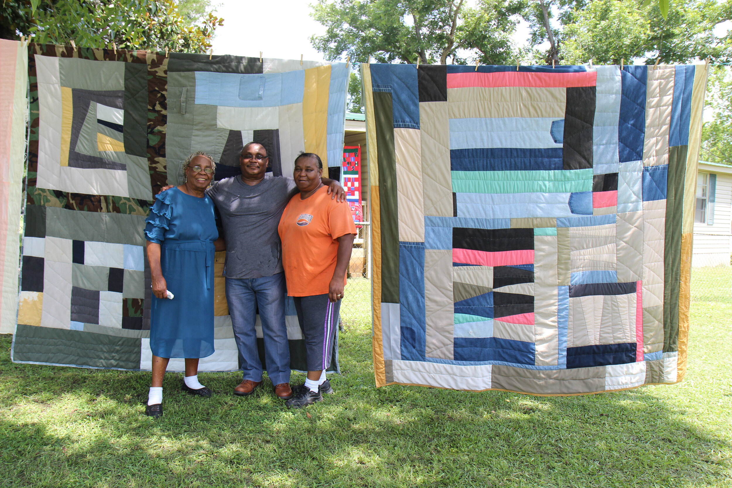  In July 2018, I traveled to Gee’s Bend, Alabama to research an exhibition,  Piece Together: The Quilts of Mary Lee Bendolph.  Mary Lee stands outside her home with two of her children, Rubin Bendolph Jr., and Essie Bendolph Pettway. Essie’s quilts h