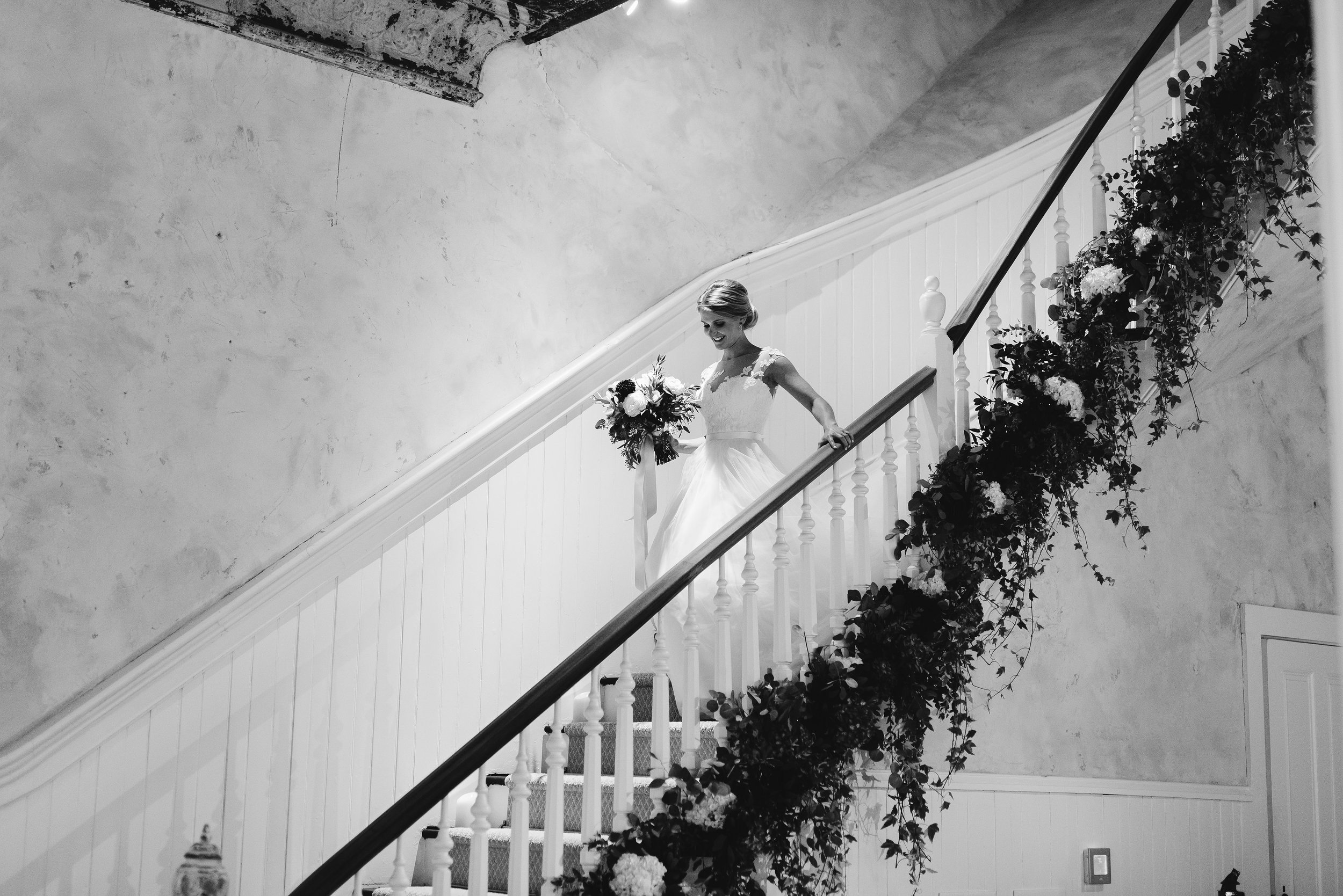 Bride descending grand staircase black and white