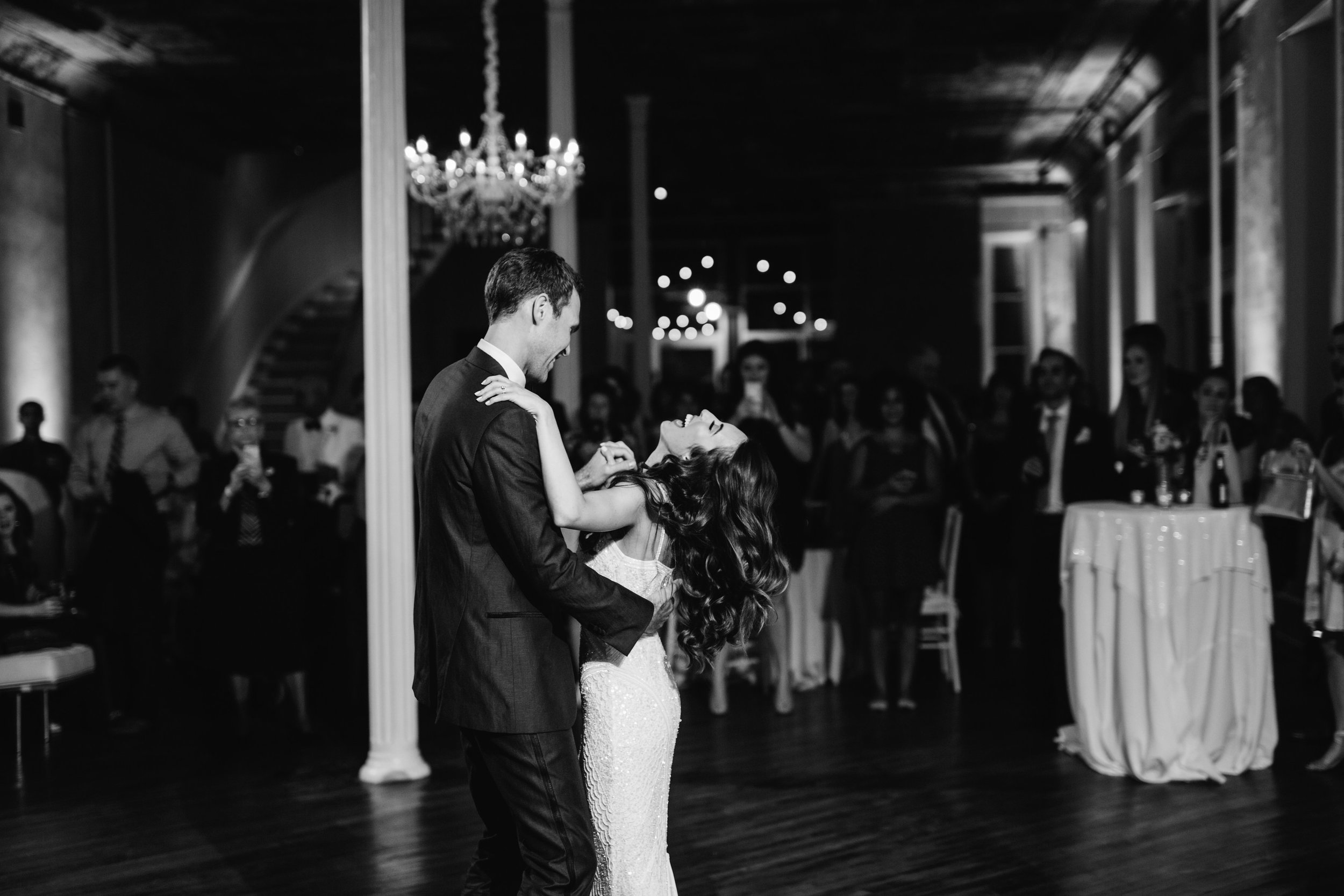 Groom and bride laughing during wedding reception black and white