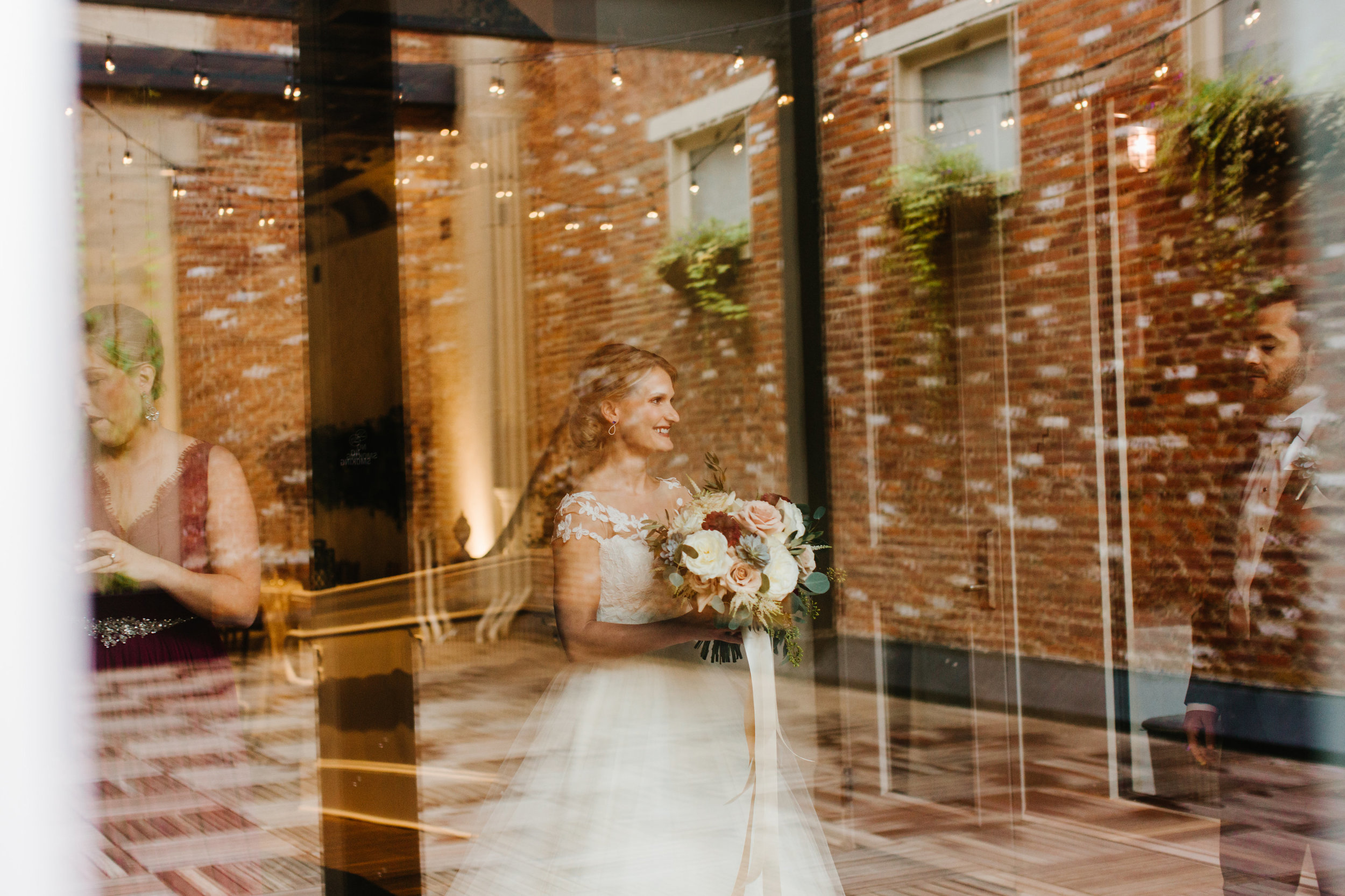 Bride smiling reflected in glass at Excelsior Lancaster PA