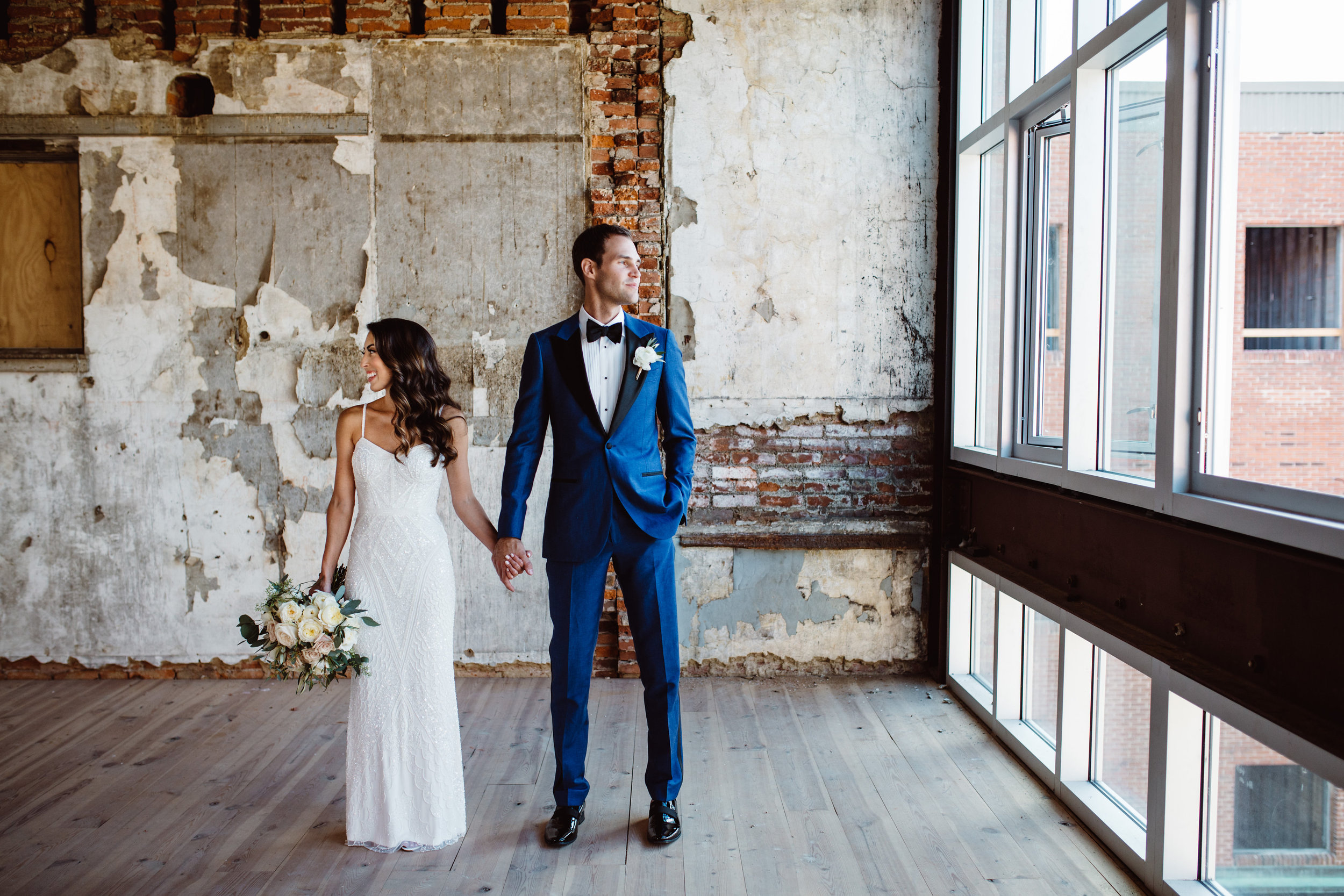 Bride and groom holding hands in antique rustic eclectic room