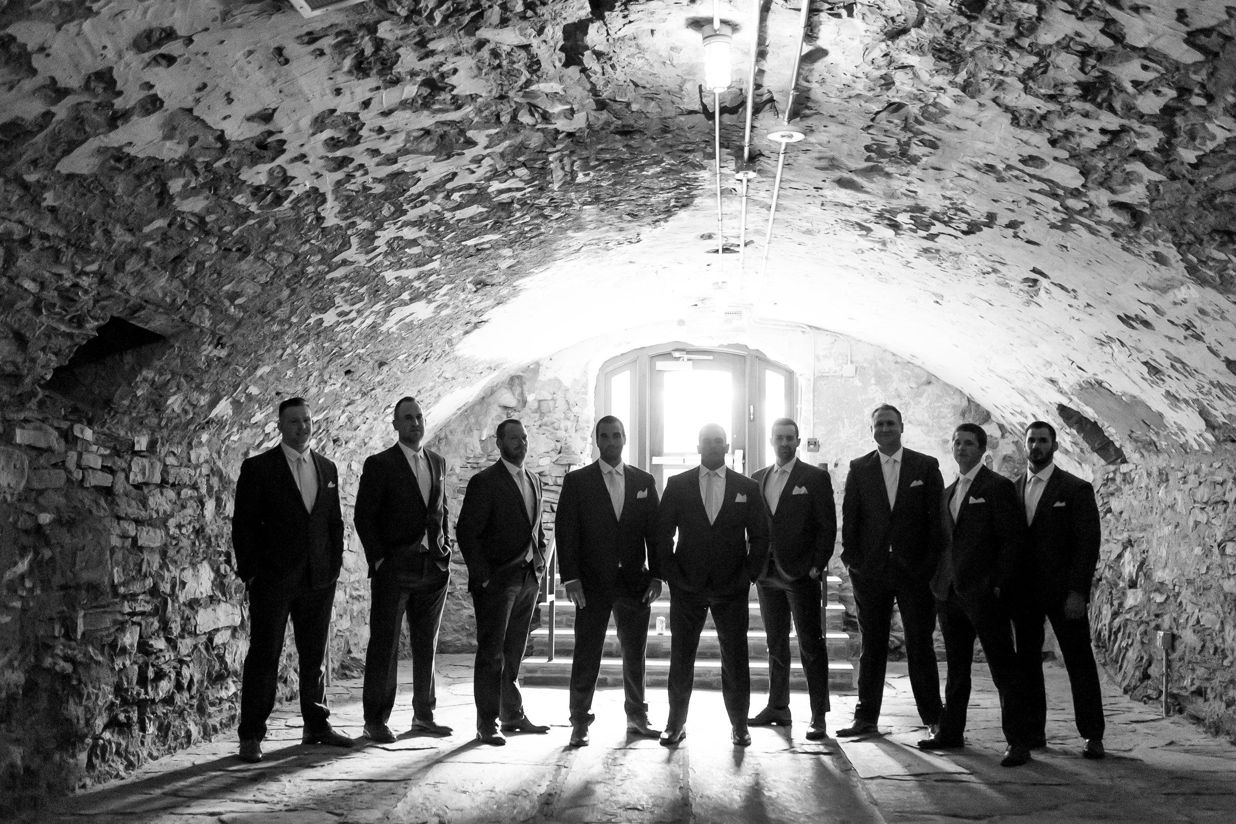 Groomsmen posing in catacombs of Excelsior wedding venue