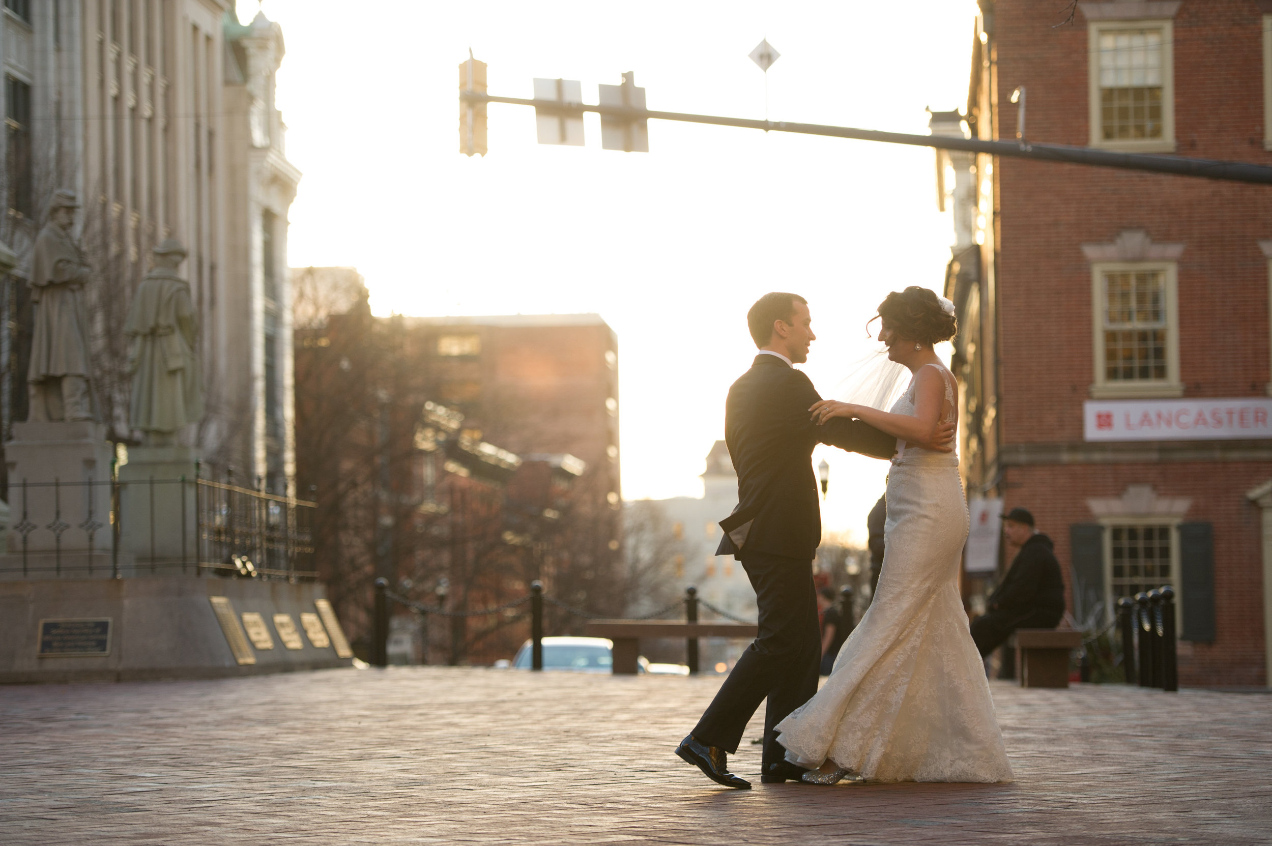 Bride and groom dancing in street