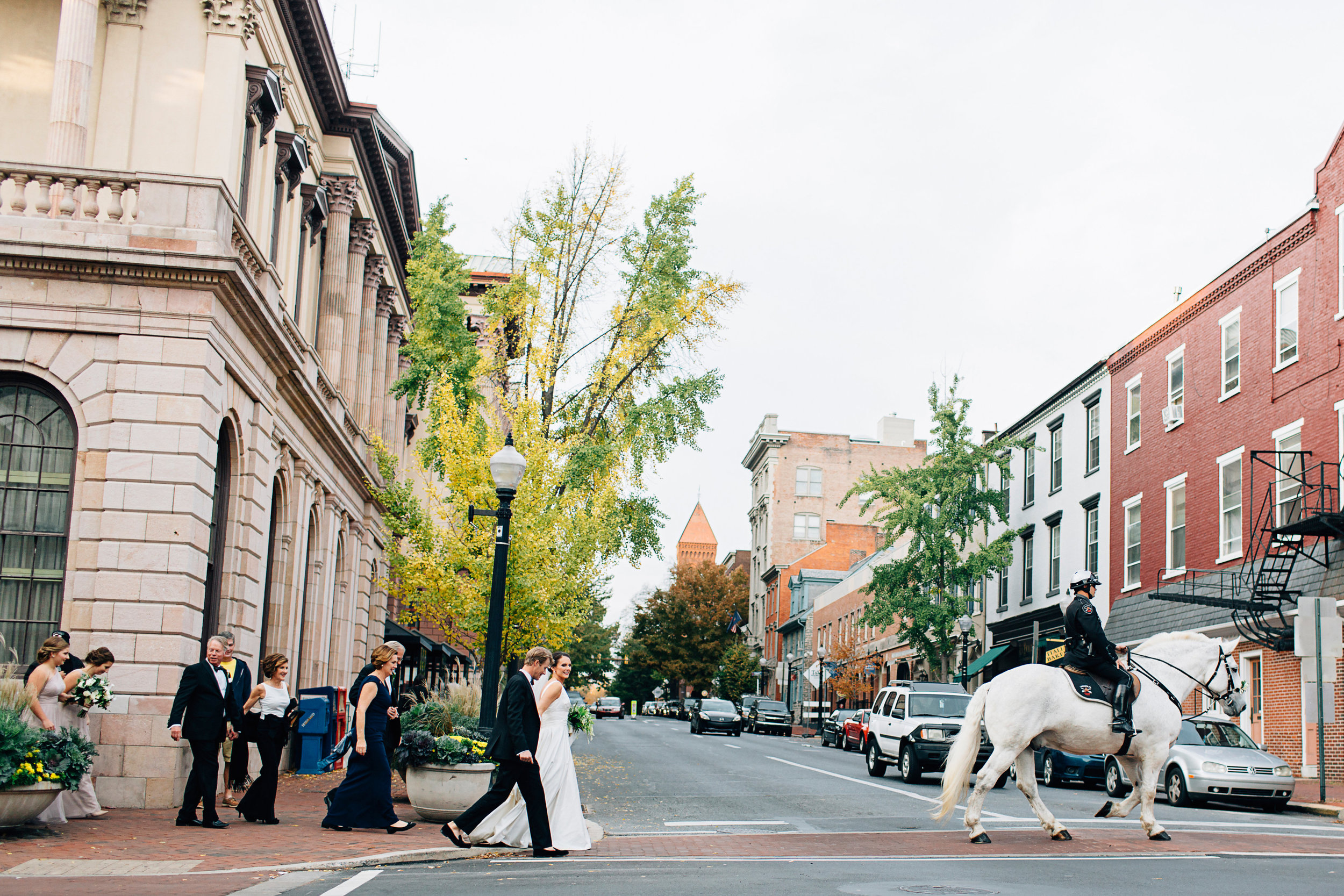 Bridal Party walking across street downtown Lancaster Pennsylvania behind mounted police on horse