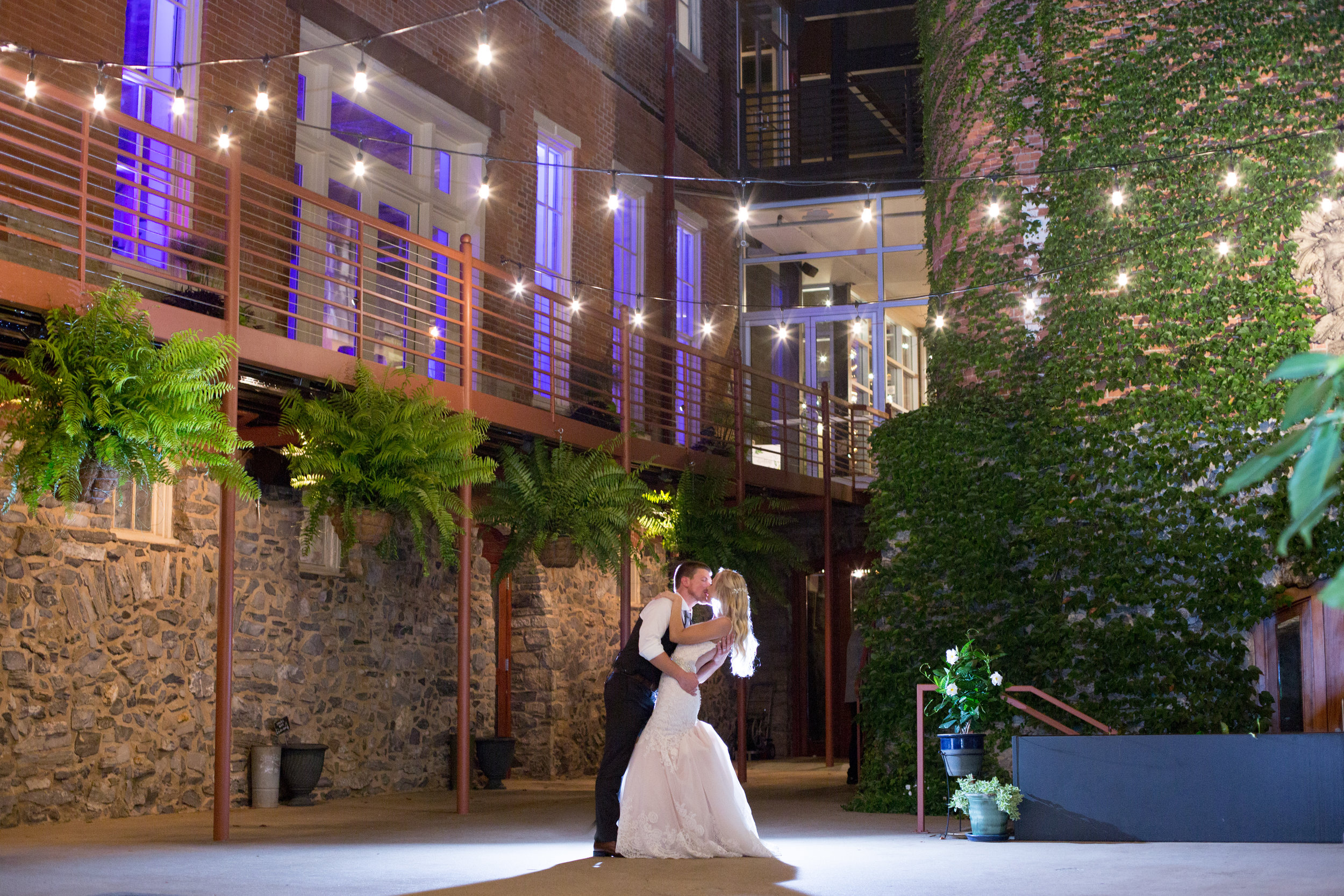 Couple dancing in garden courtyard outdoor space lit up at night