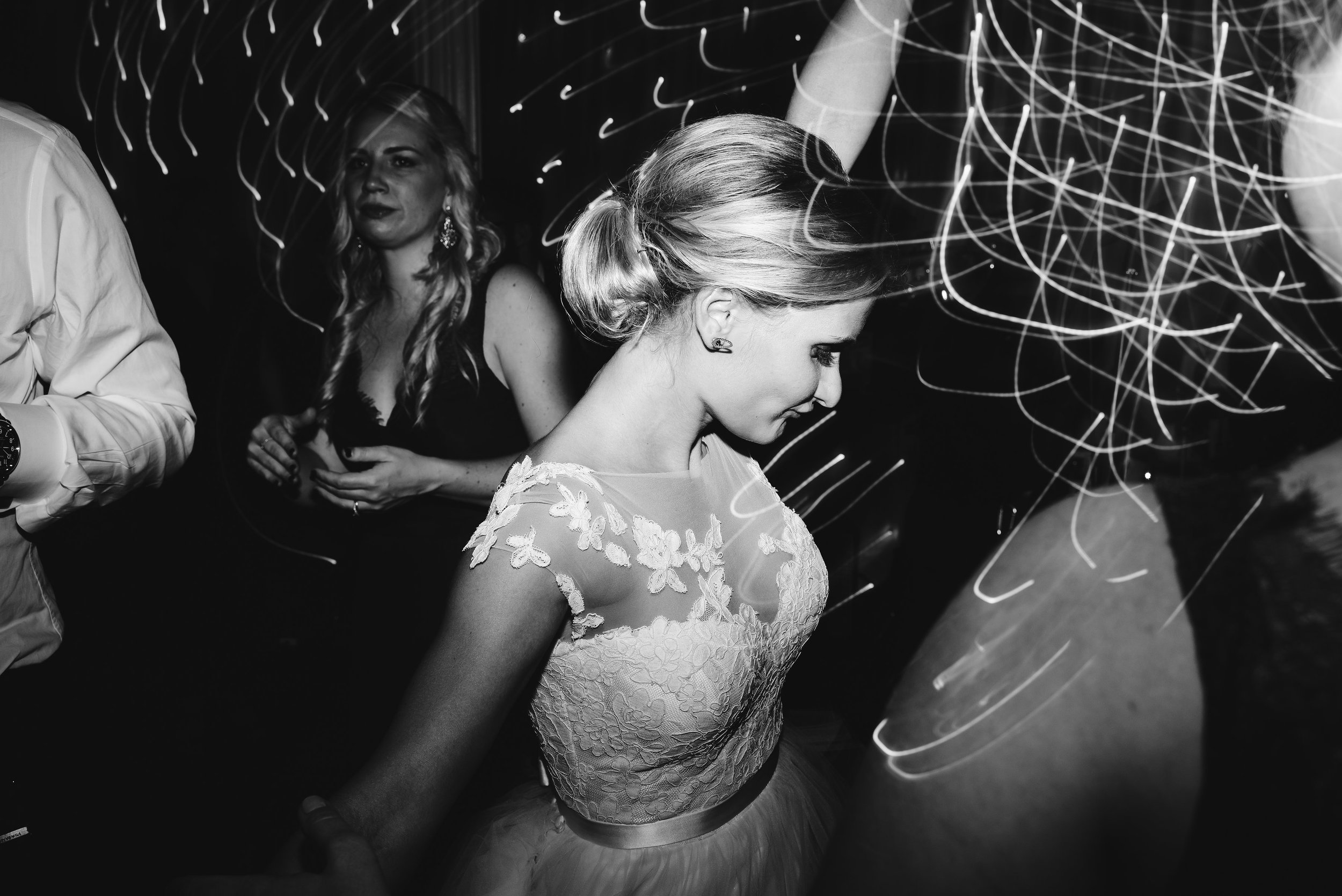 Bride dancing at reception hand in the air black and white