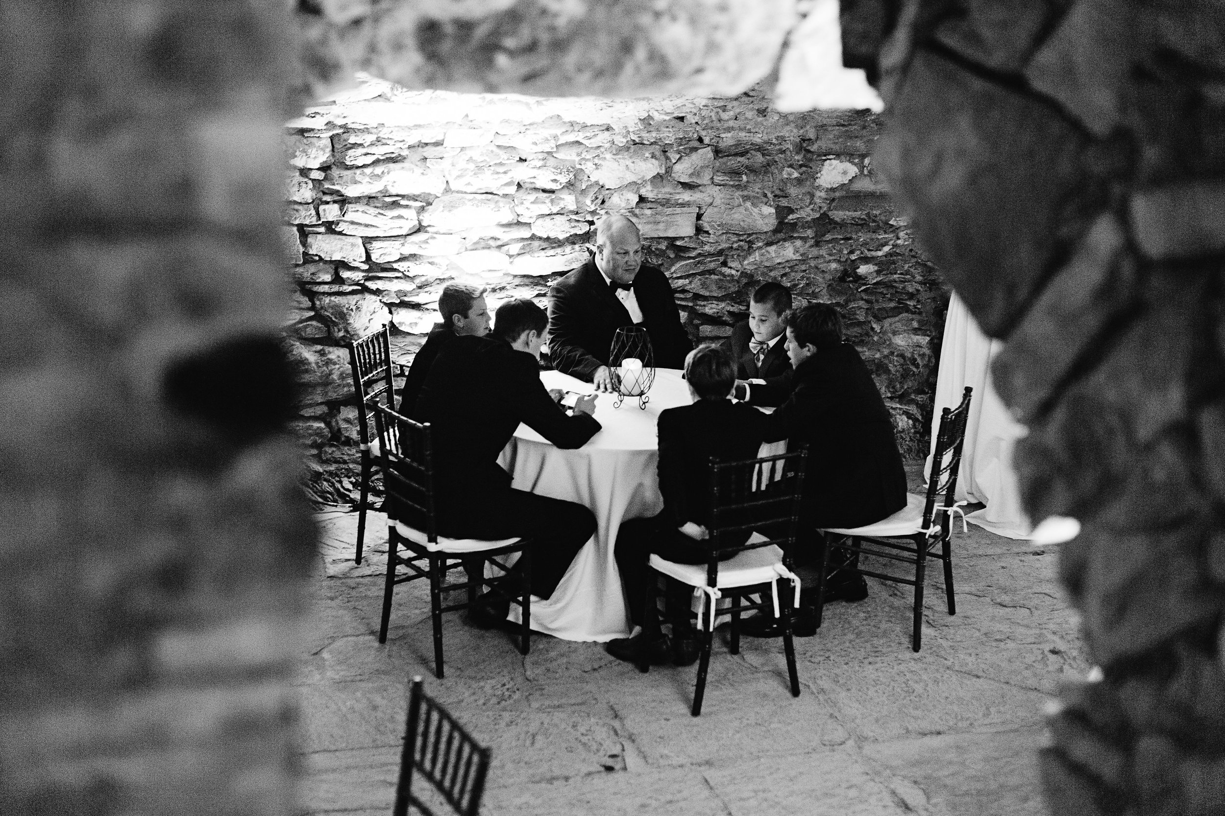 Men sitting around table in catacombs black and white