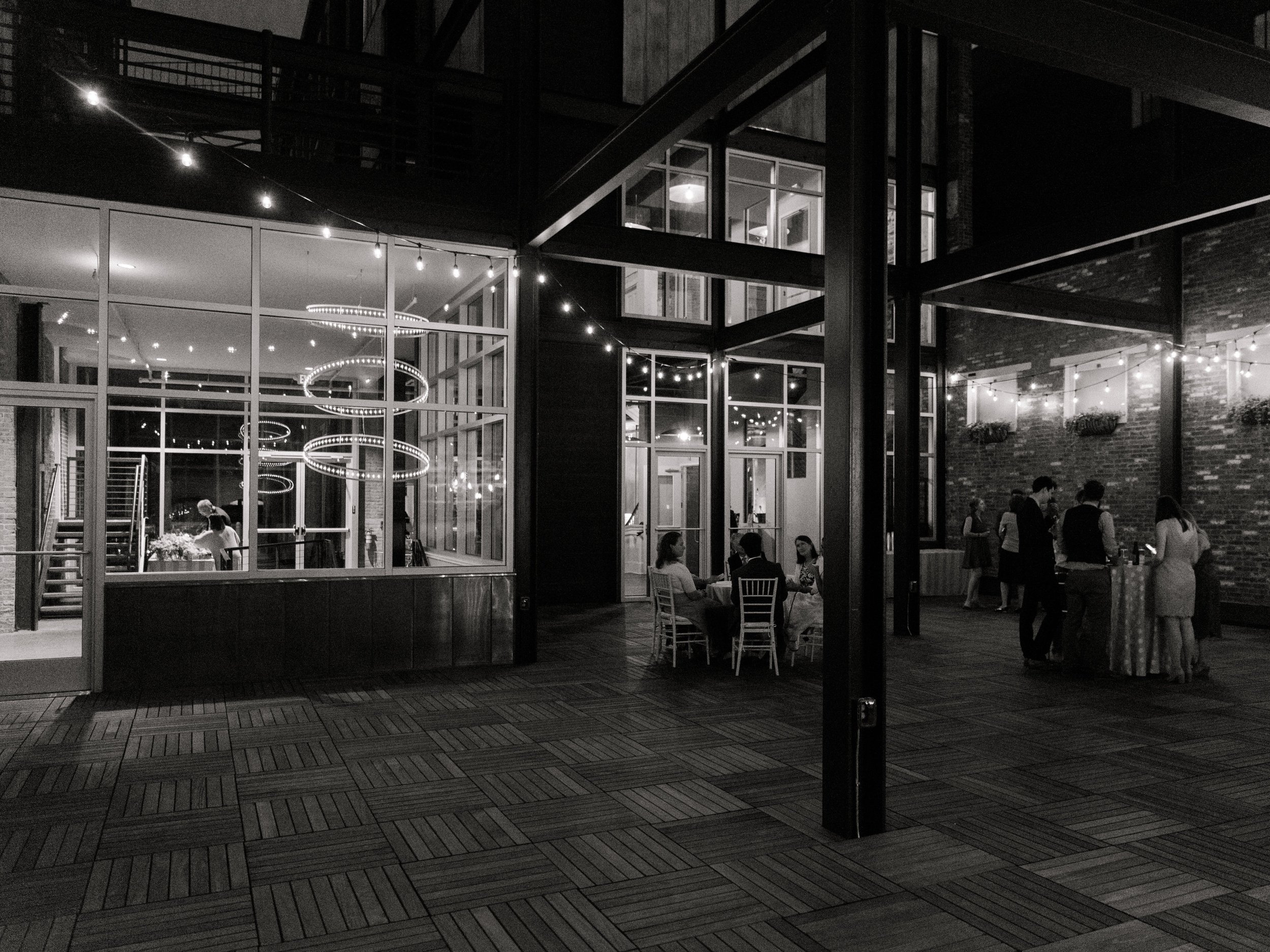 Outdoor patio on Terrace looking into Excelsior building lit up at night black and white