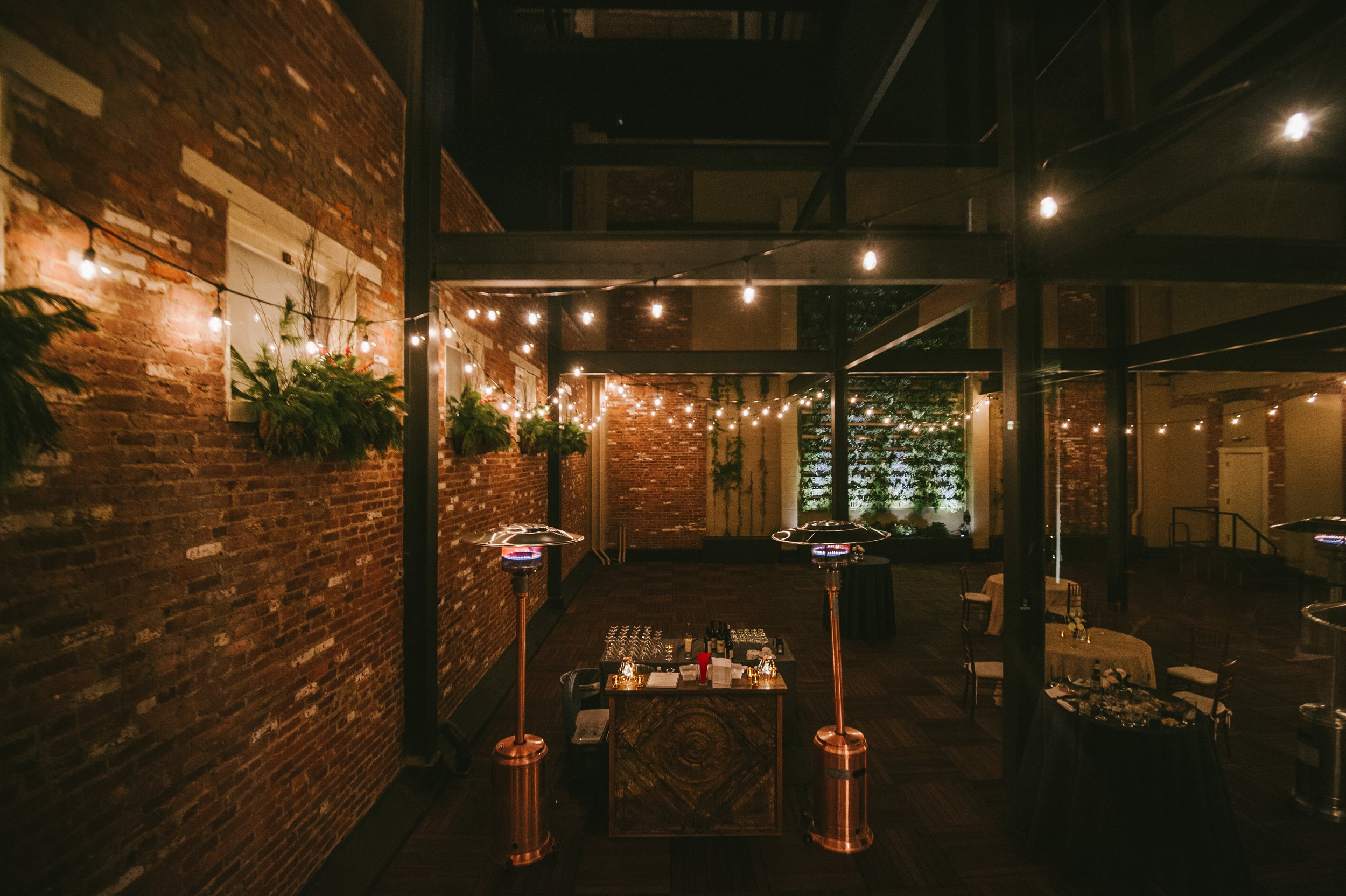 Outdoor event space at night canopy lights hanging plants