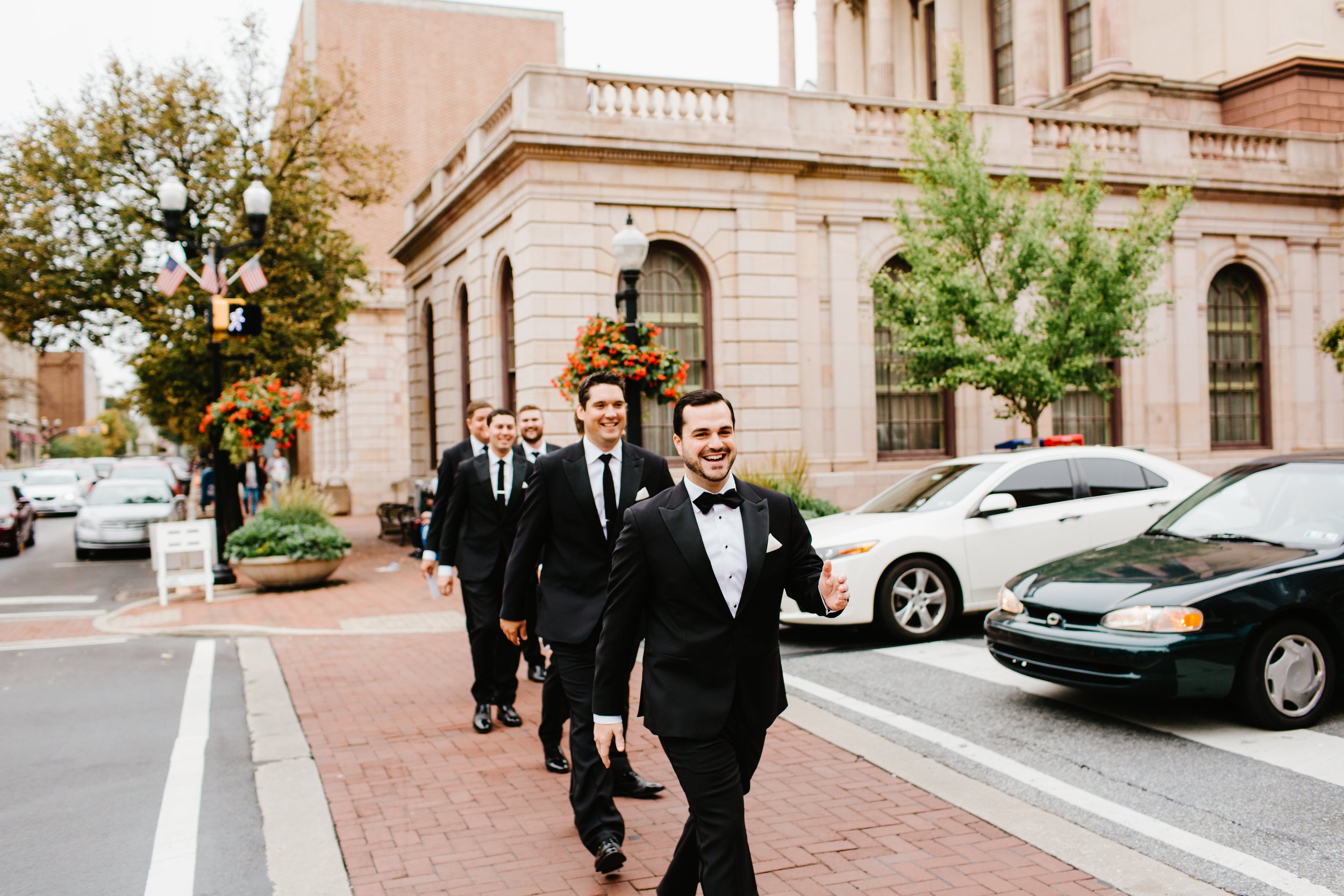 Groom and groomsmen walking across street city center
