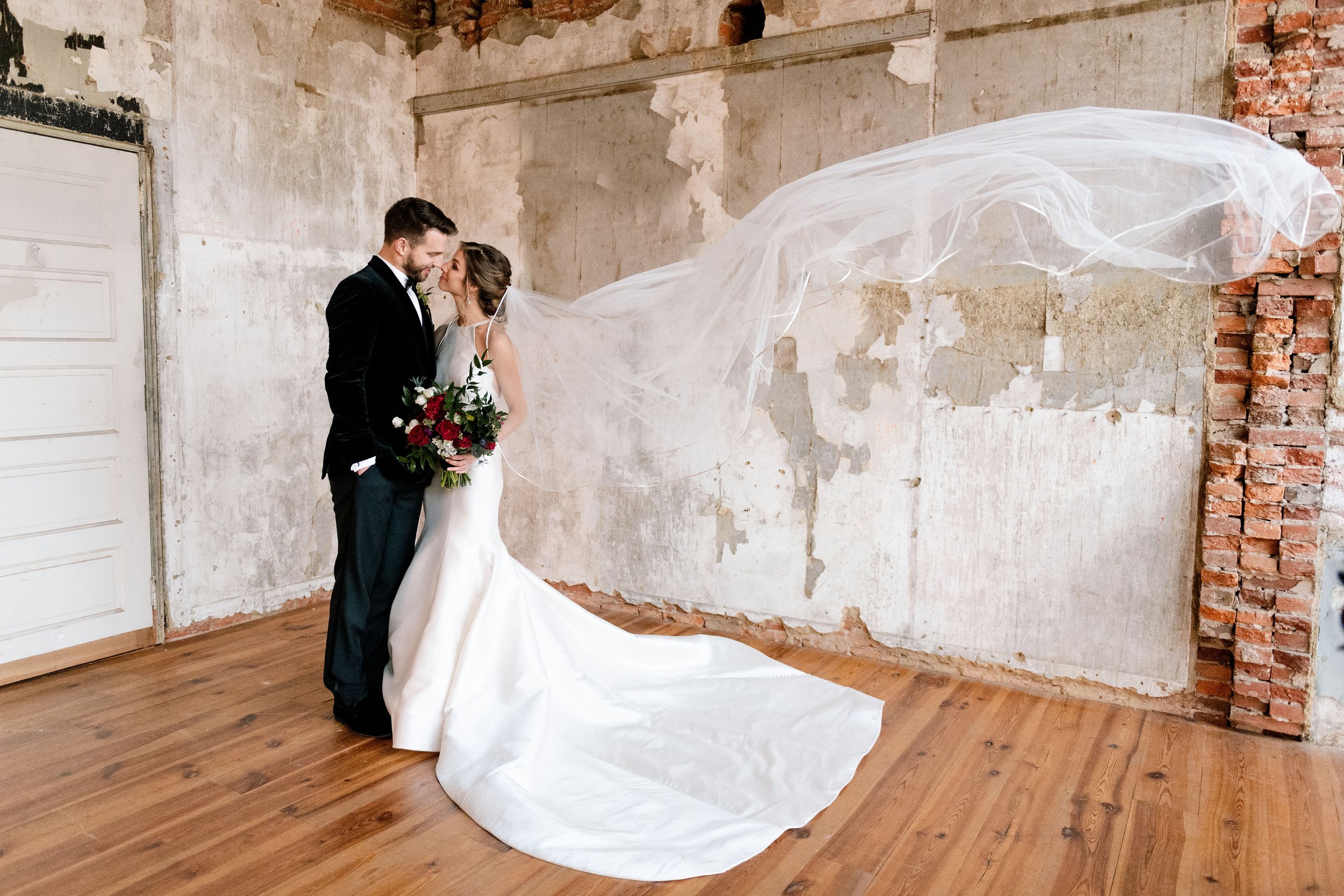 Bride and groom with floating veil rustic room