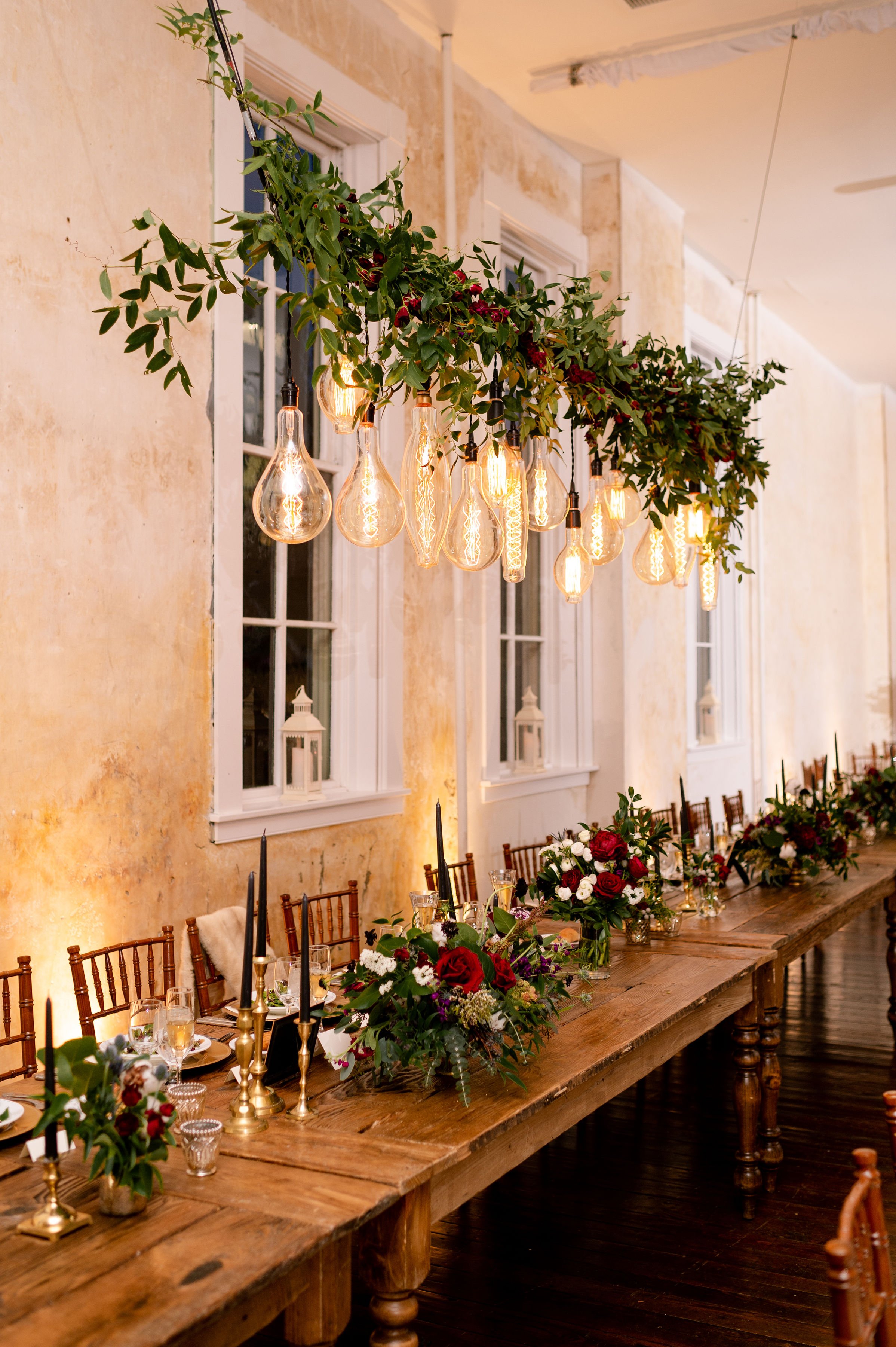 Hanging greenery and edison bulbs above wedding reception tables nighttime at Excelsior Lancaster PA