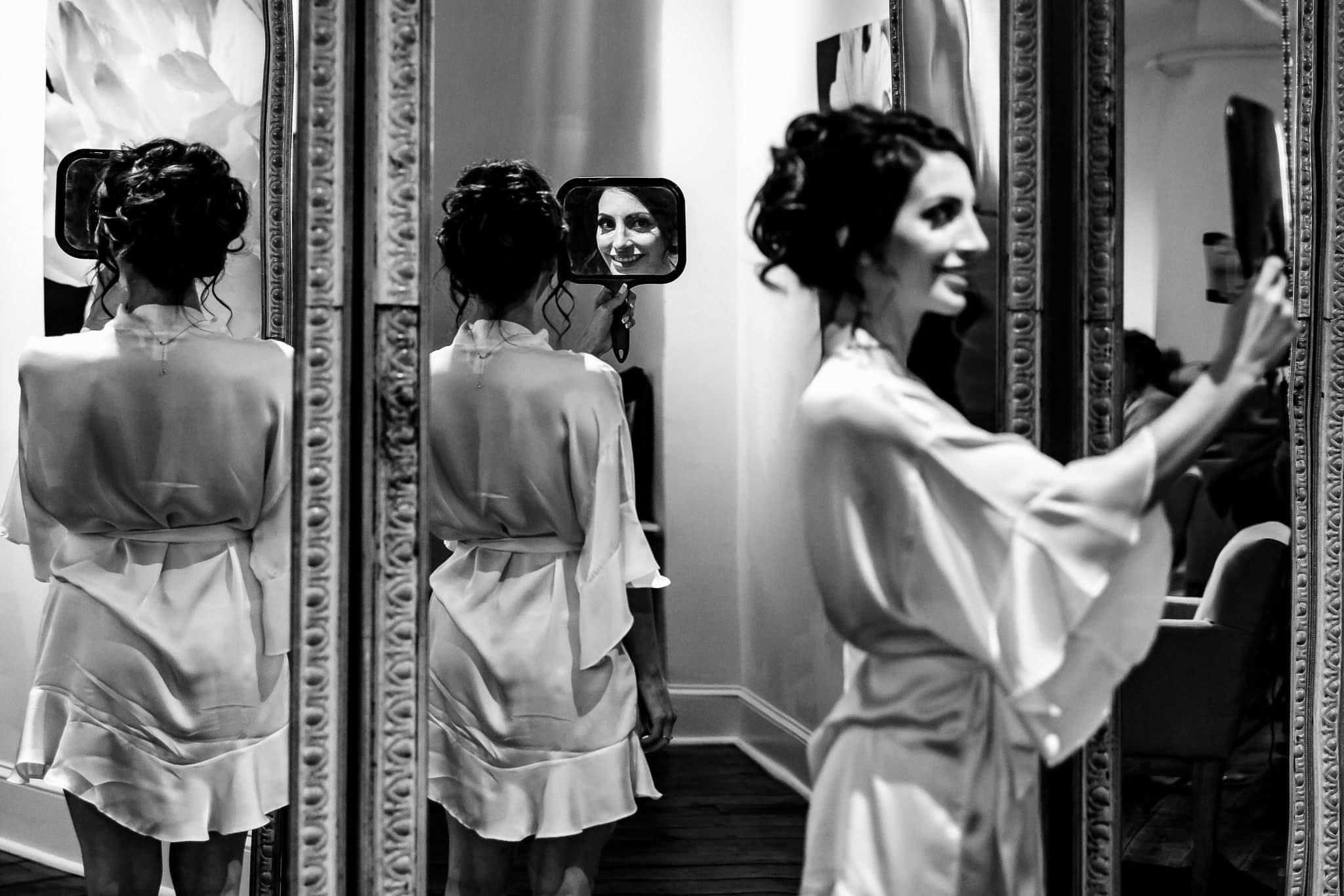 Bride getting ready in mirrors black and white