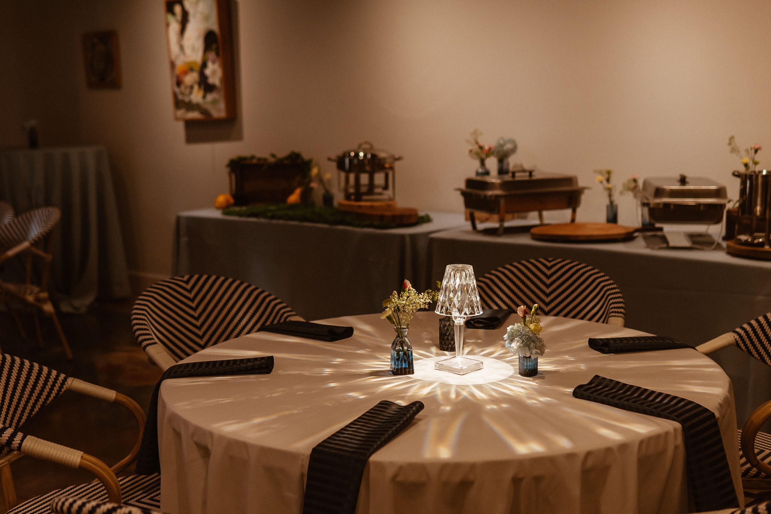 Table with small lighted glass lamp centerpiece