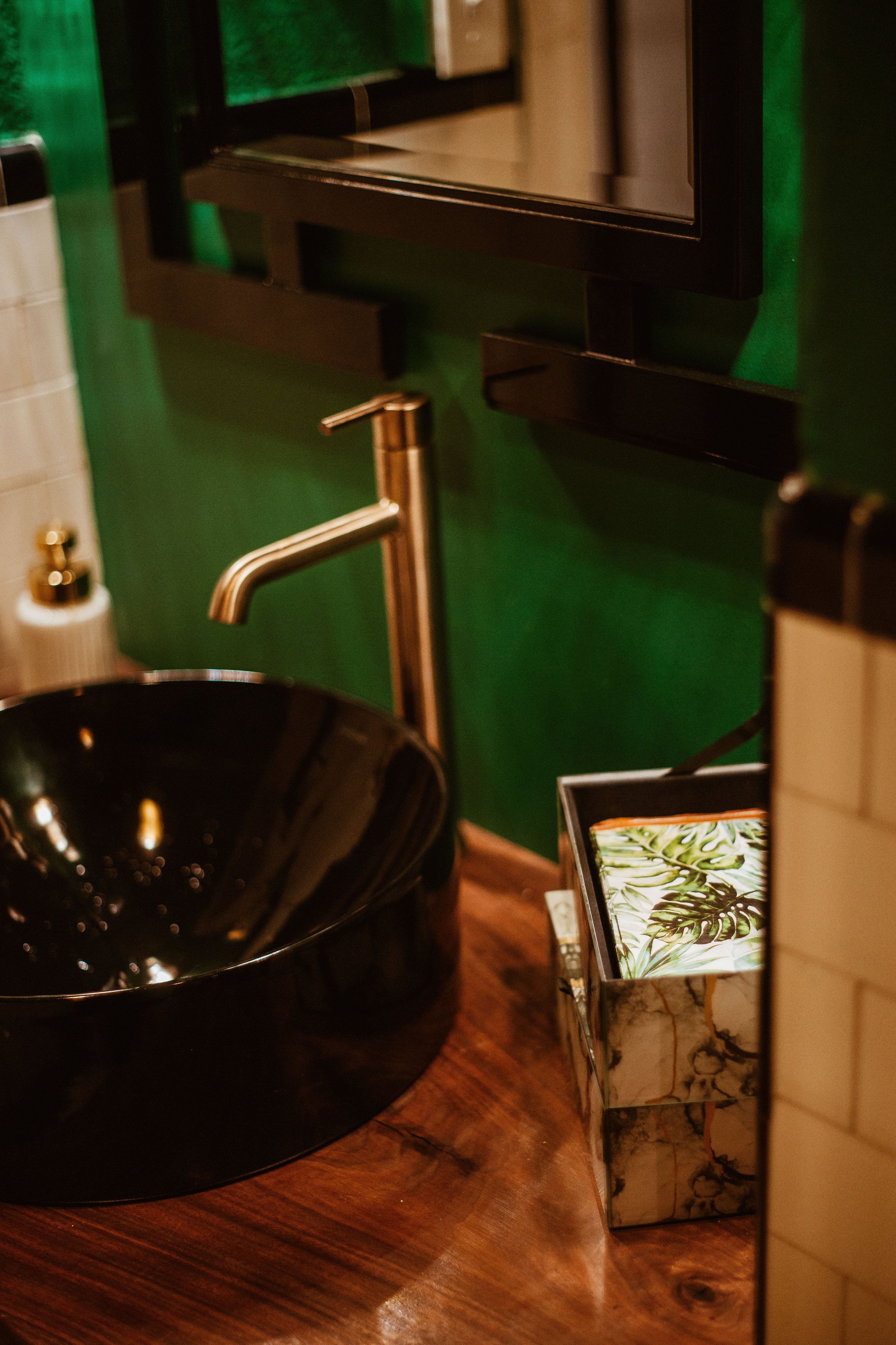 Golden faucet on green backdrop bathroom