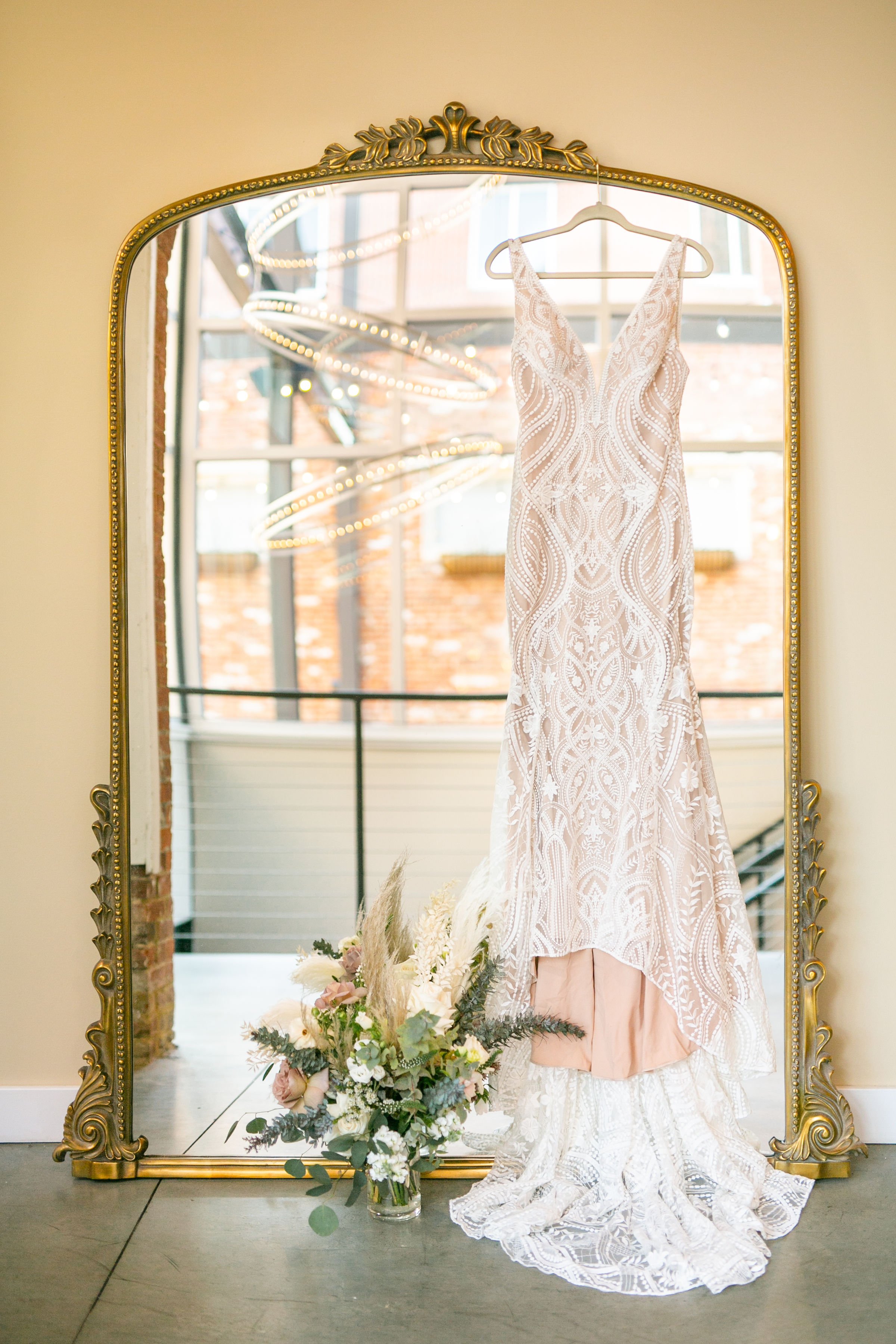 Sparkly bridal gown hanging from large floor mirror
