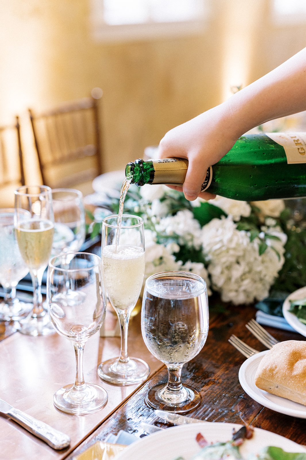 Pouring champagne at wedding reception dinner table