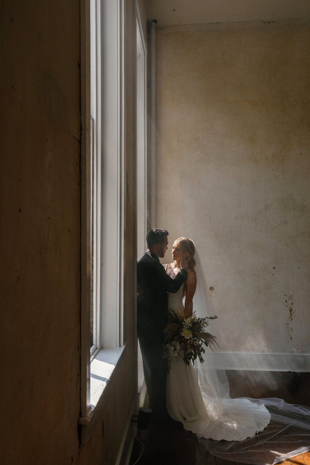 bride and groom hazy portrait eclectic and moody with large windows