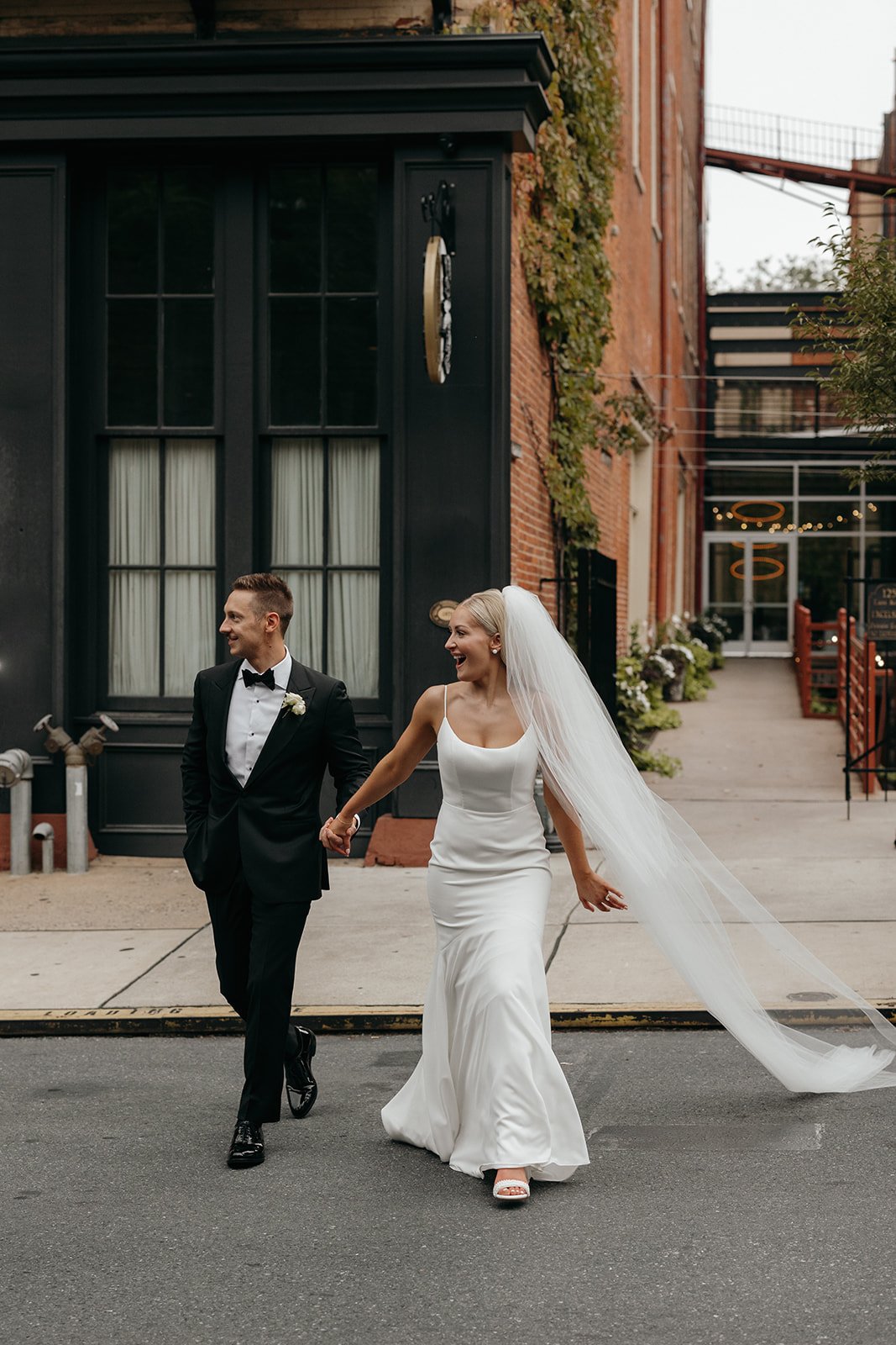 Bride leading groom across street in front of Excelsior lancaster pa