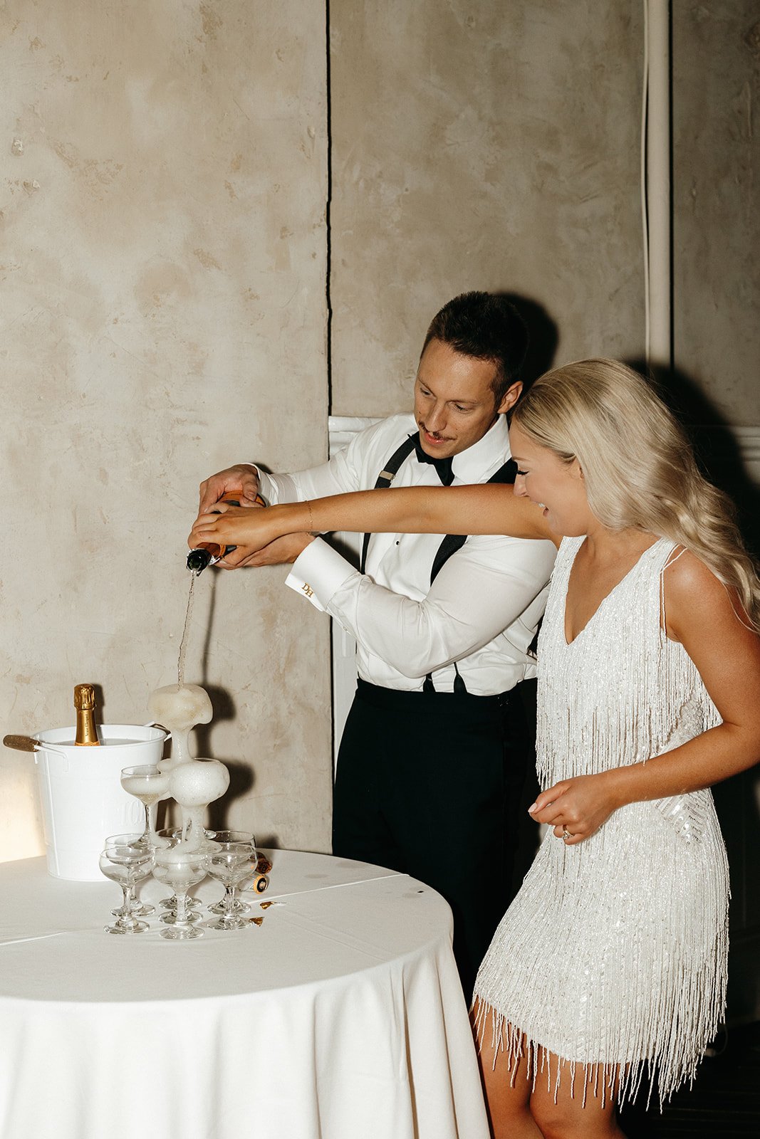 Bride and Groom pouring champagne at reception