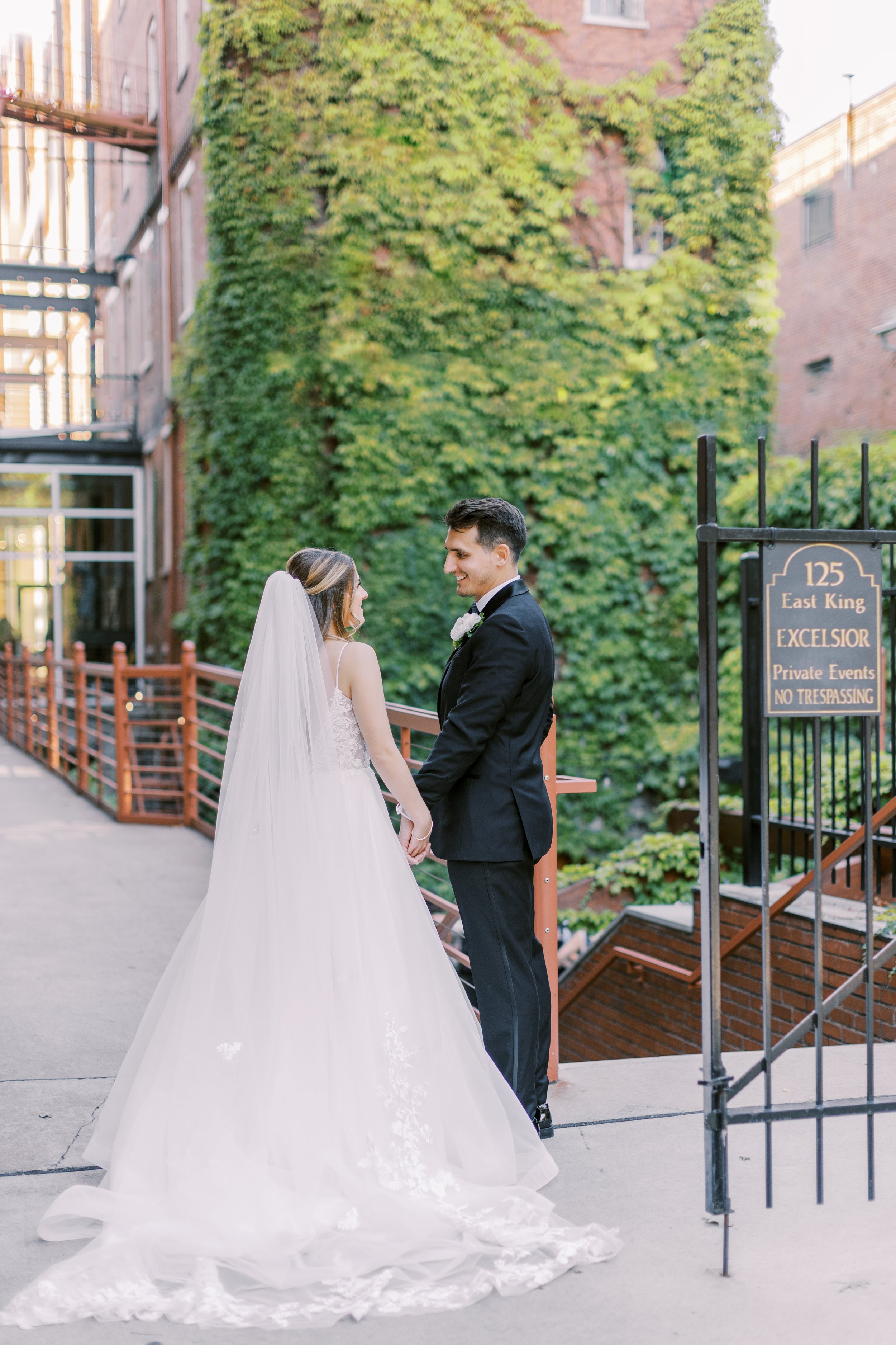 Bride and groom portrait outdoors in Lancaster city downtown in front of ivy covered green wall at Excelsior