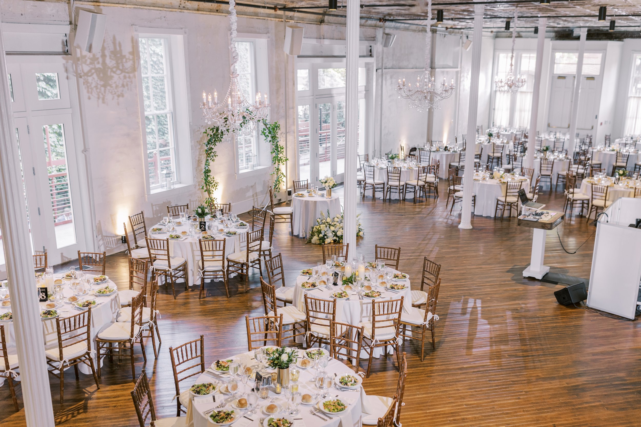 Wedding reception dinner table set up with greenery arch in Grand Salon at Excelsior