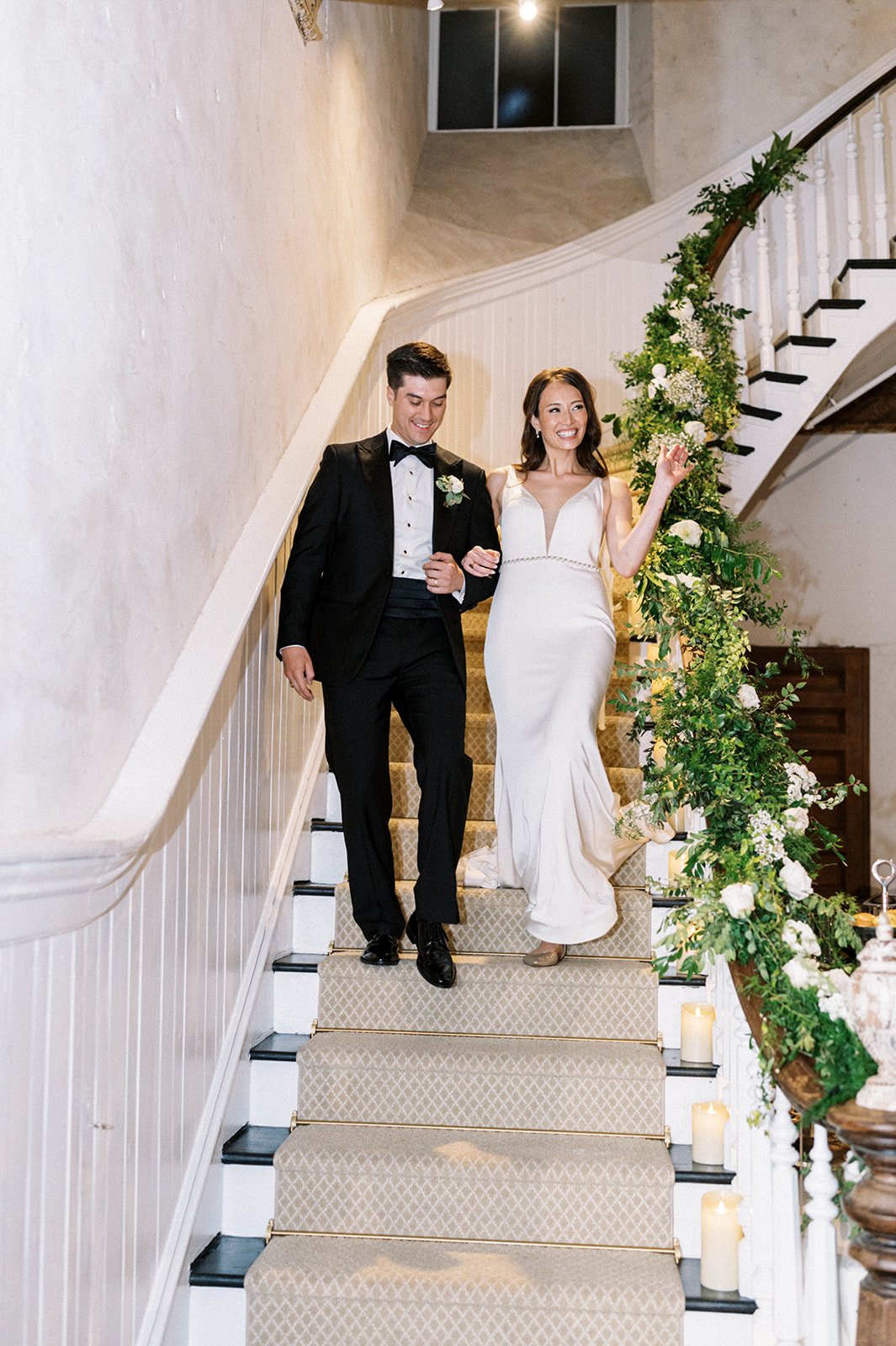 Couple descending the grand historic staircase in the Grand Salon of Excelsior wedding venue