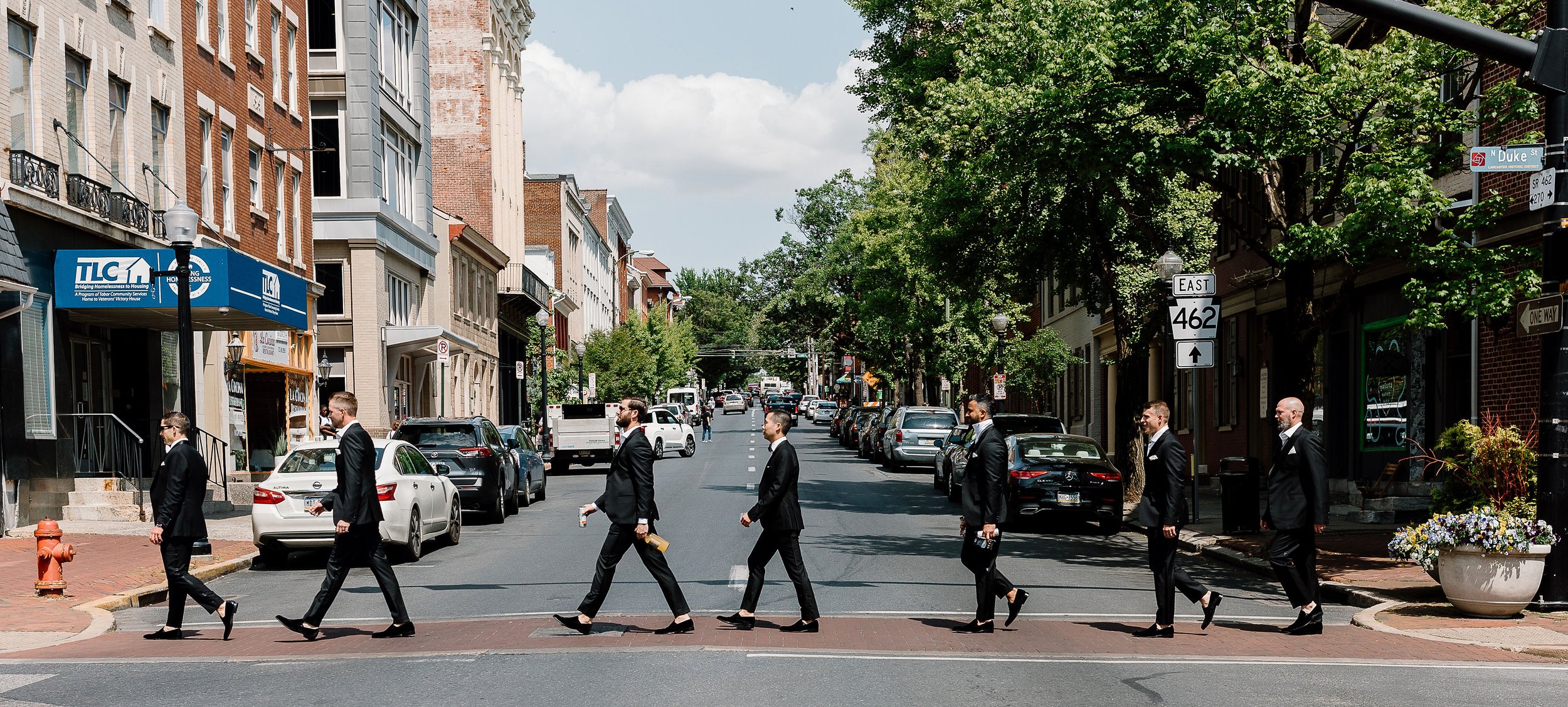 Groom and groomsmen walking across the street Lancaster city a la The Beatles Abbey Road
