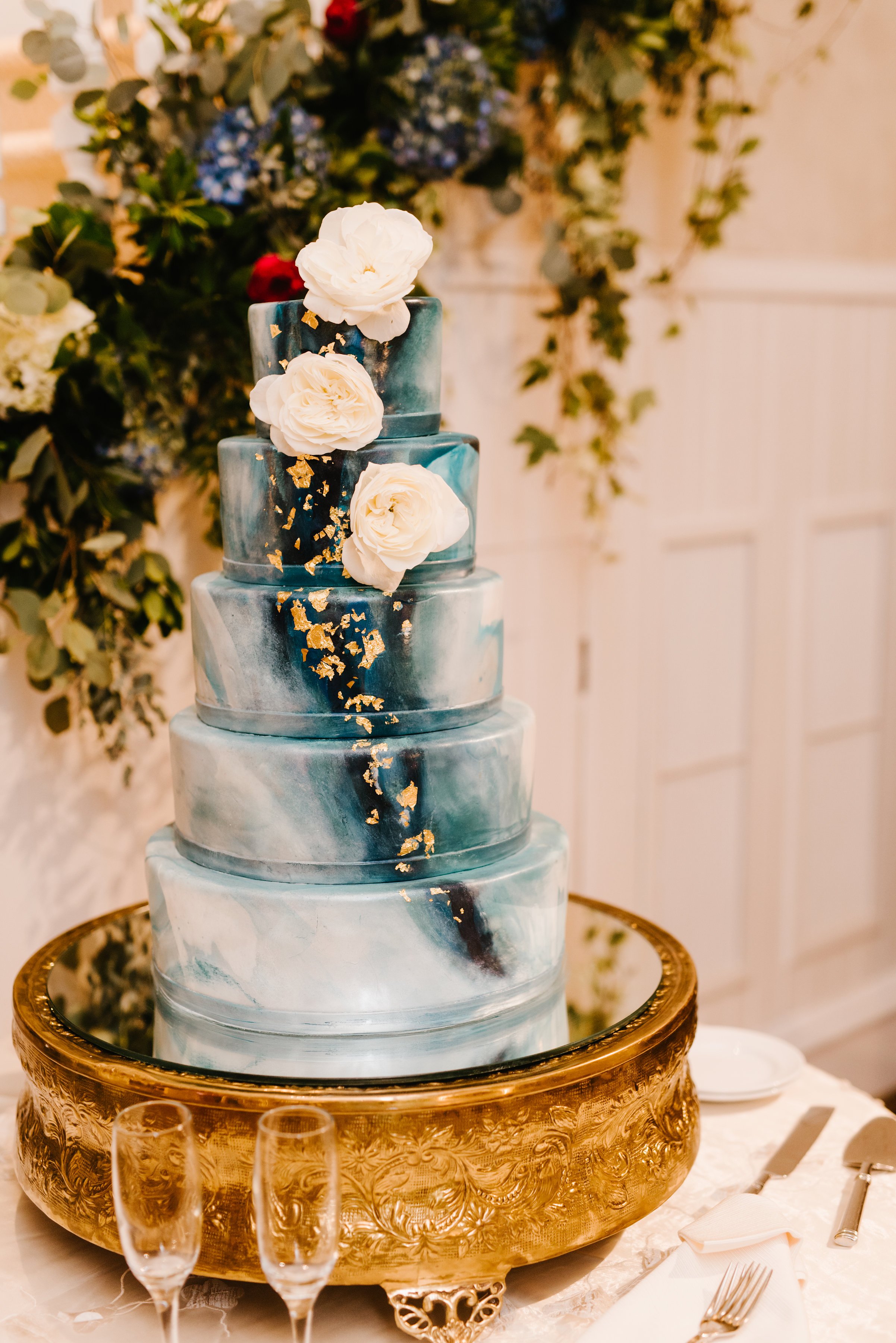 Blue and gold marbled 5 tiered cake with white roses