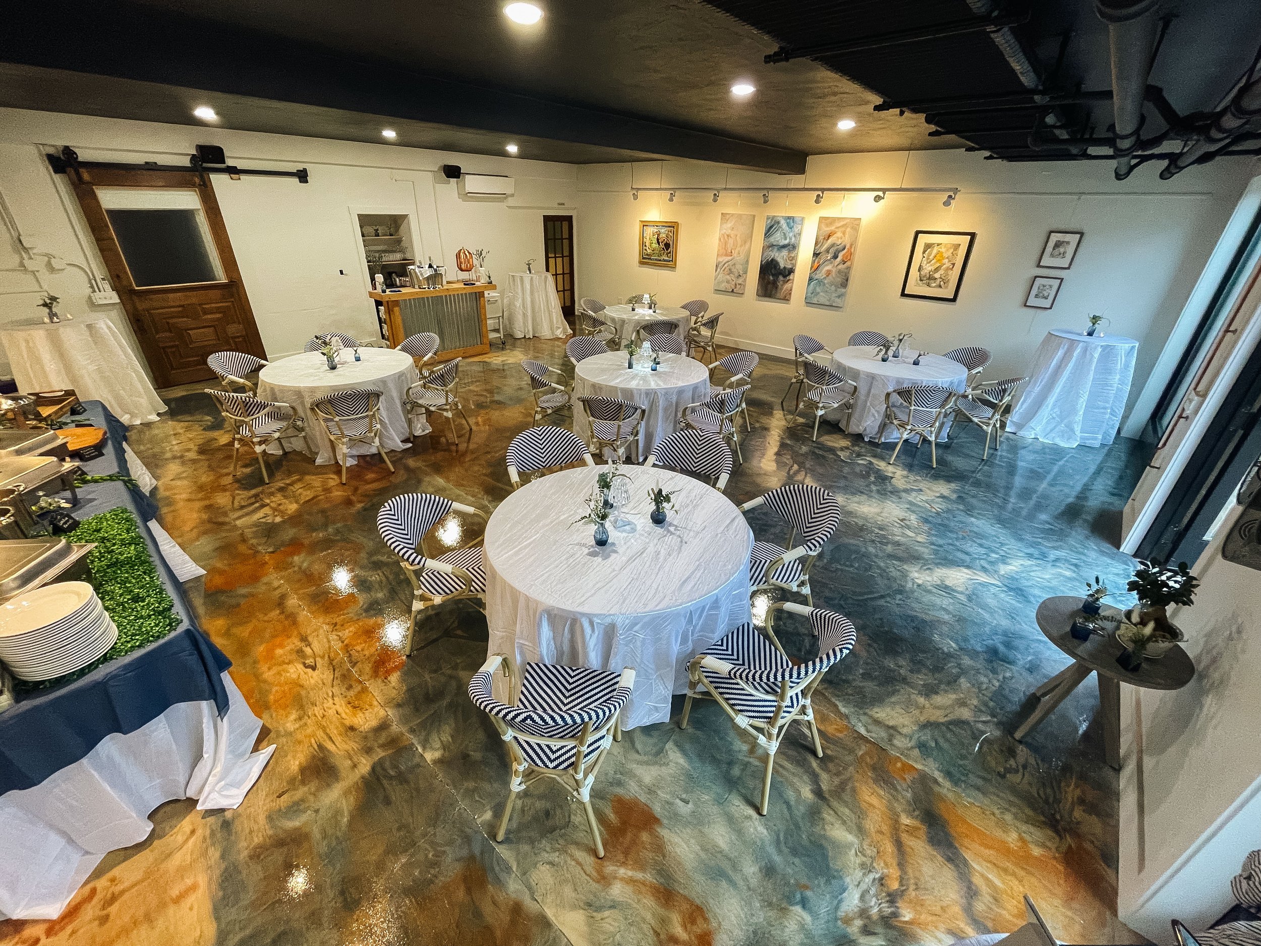 Showcasing the swirling epoxy floors of indoor dining space round tables
