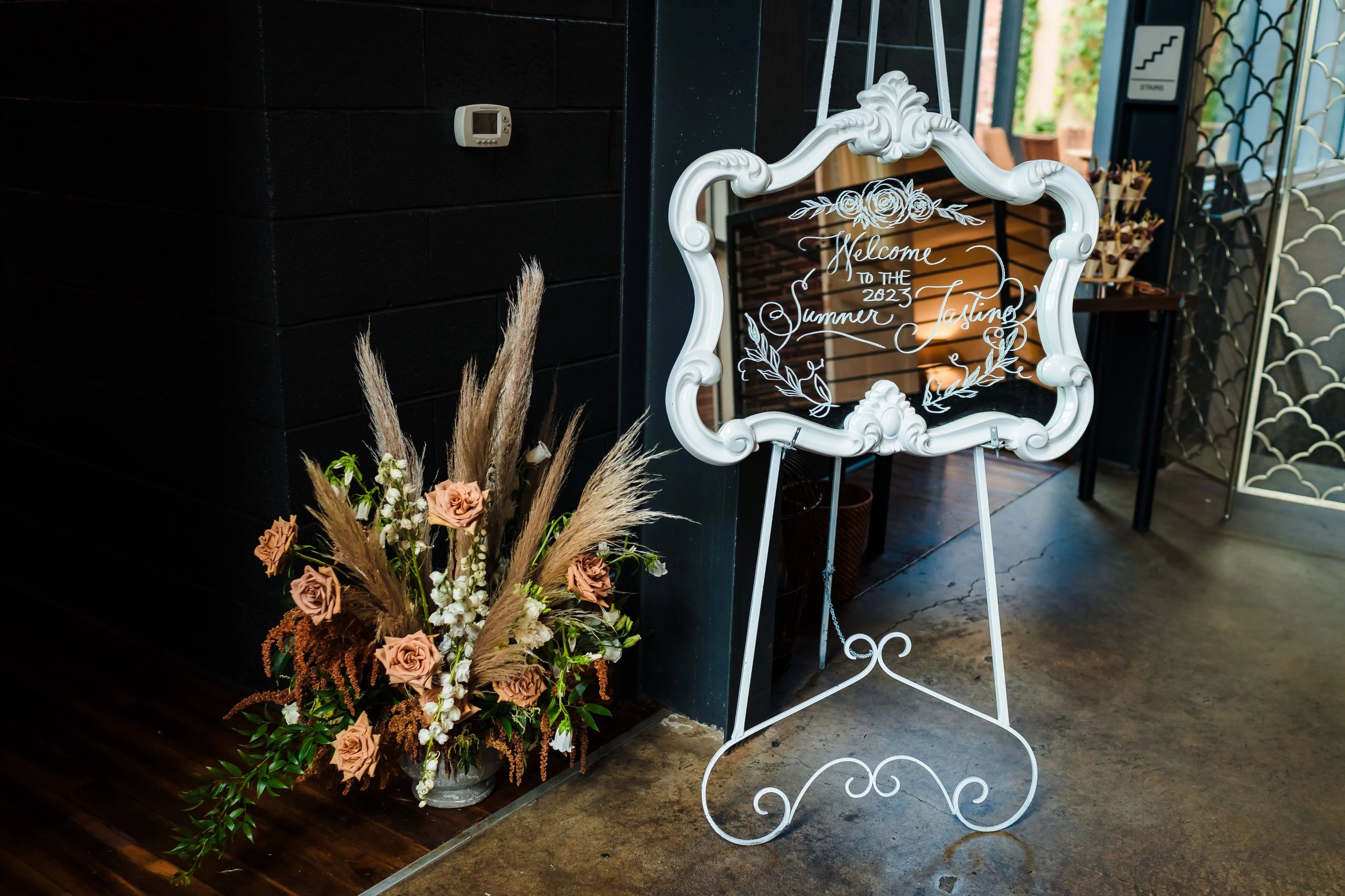 Event decor flowers and grasses mirrored sign