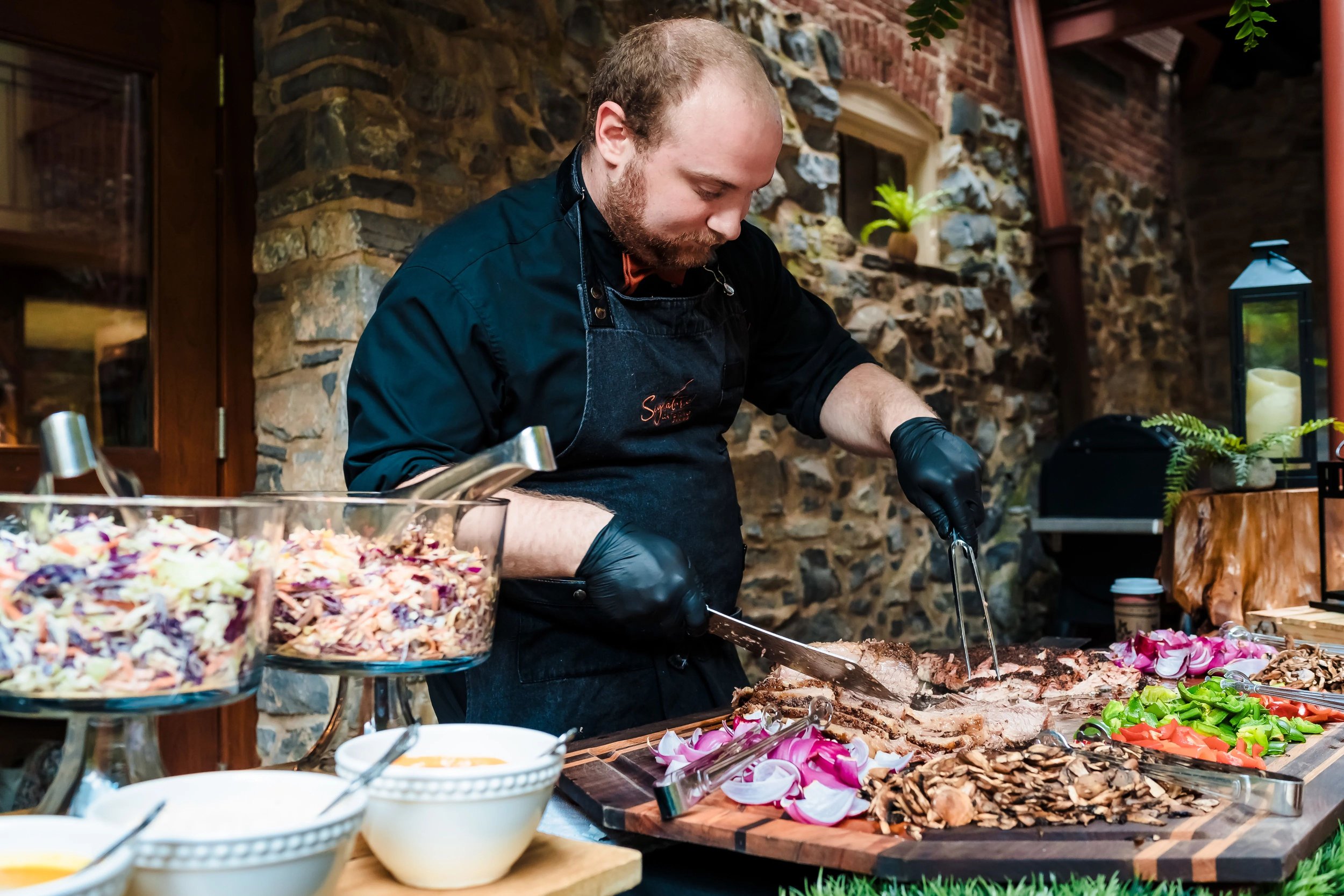 Man carving meat at outdoor food station
