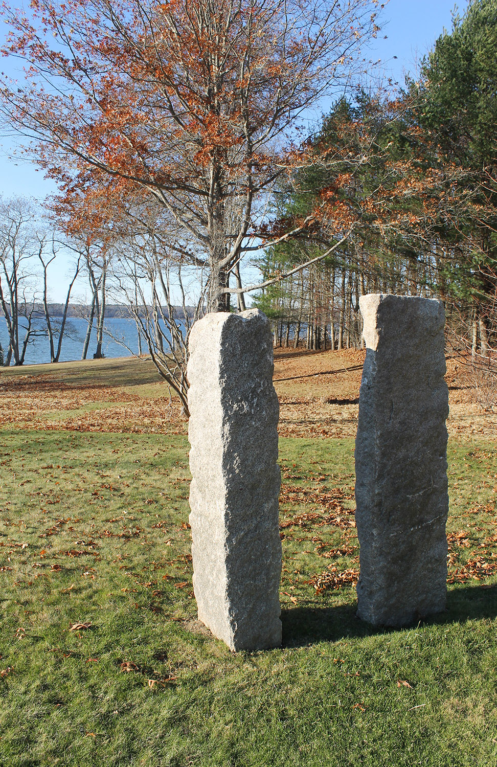 A simple stone sculpture mediates between house and bay.