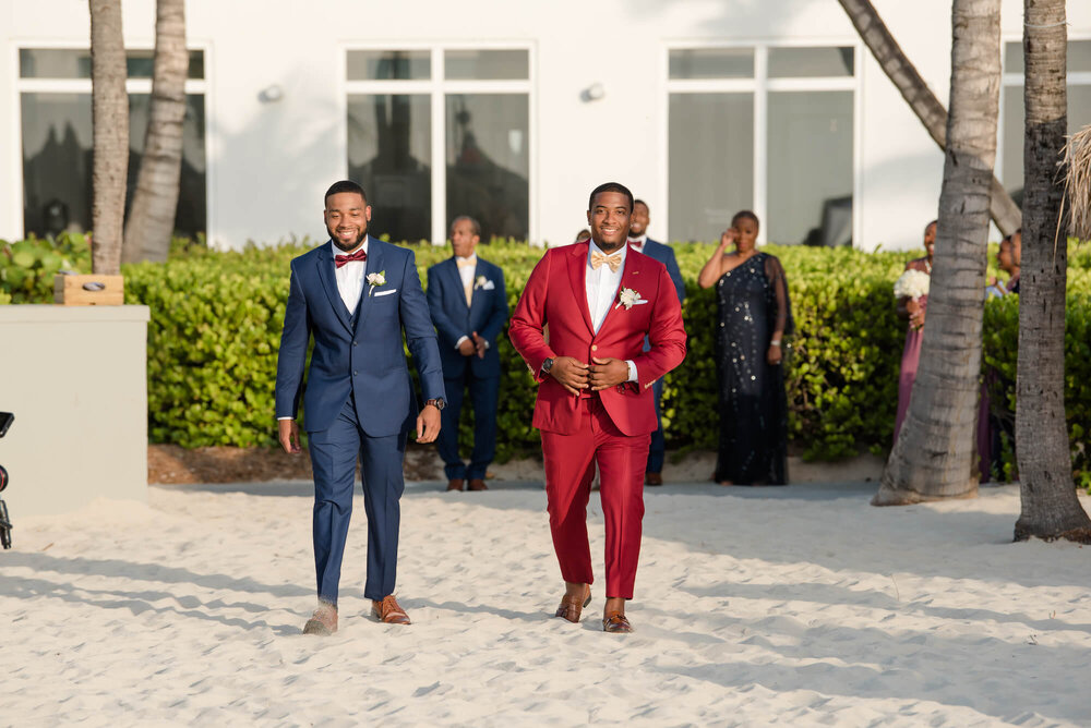 laura-how-to-plan-a-destination-wedding-in-oranjestad-aruba-hilton-aruba-resort-black-destination-bride-desti-tv-desti-guide-to-destination-weddings-2020-beach-groom-red-tuxedo.jpg