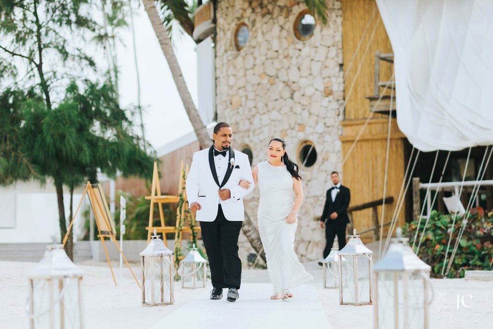 destibride-nicole-how-to-plan-a-destination-wedding-in-punta-cana-dominican-republic-jellyfish-restaurant-black-destination-bride-desti-tv-desti-guide-to-destination-weddings-2021-beach-groom-white-black-tuxedo-aisle.jpg
