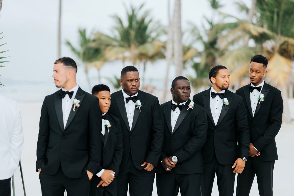 destibride-nicole-how-to-plan-a-destination-wedding-in-punta-cana-dominican-republic-jellyfish-restaurant-black-destination-bride-desti-tv-desti-guide-to-destination-weddings-2021-groomsmen-black-tuxedos-beach.jpg