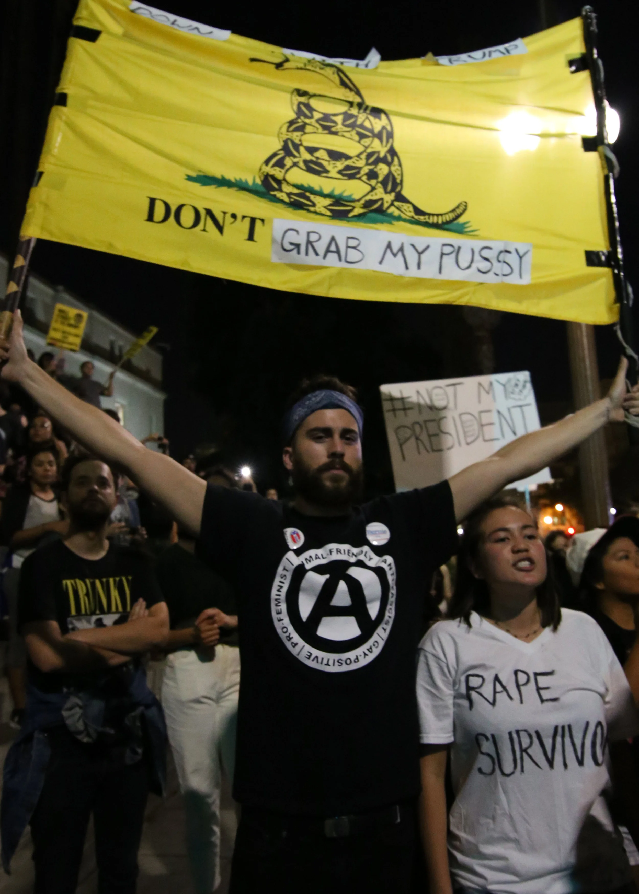 Daniel Fernandez holds up a flag while Lara Freedman voices her anger at the protest in response to the outcome of the presidential election in Downtown Los Angeles on Nov. 9, 2016.