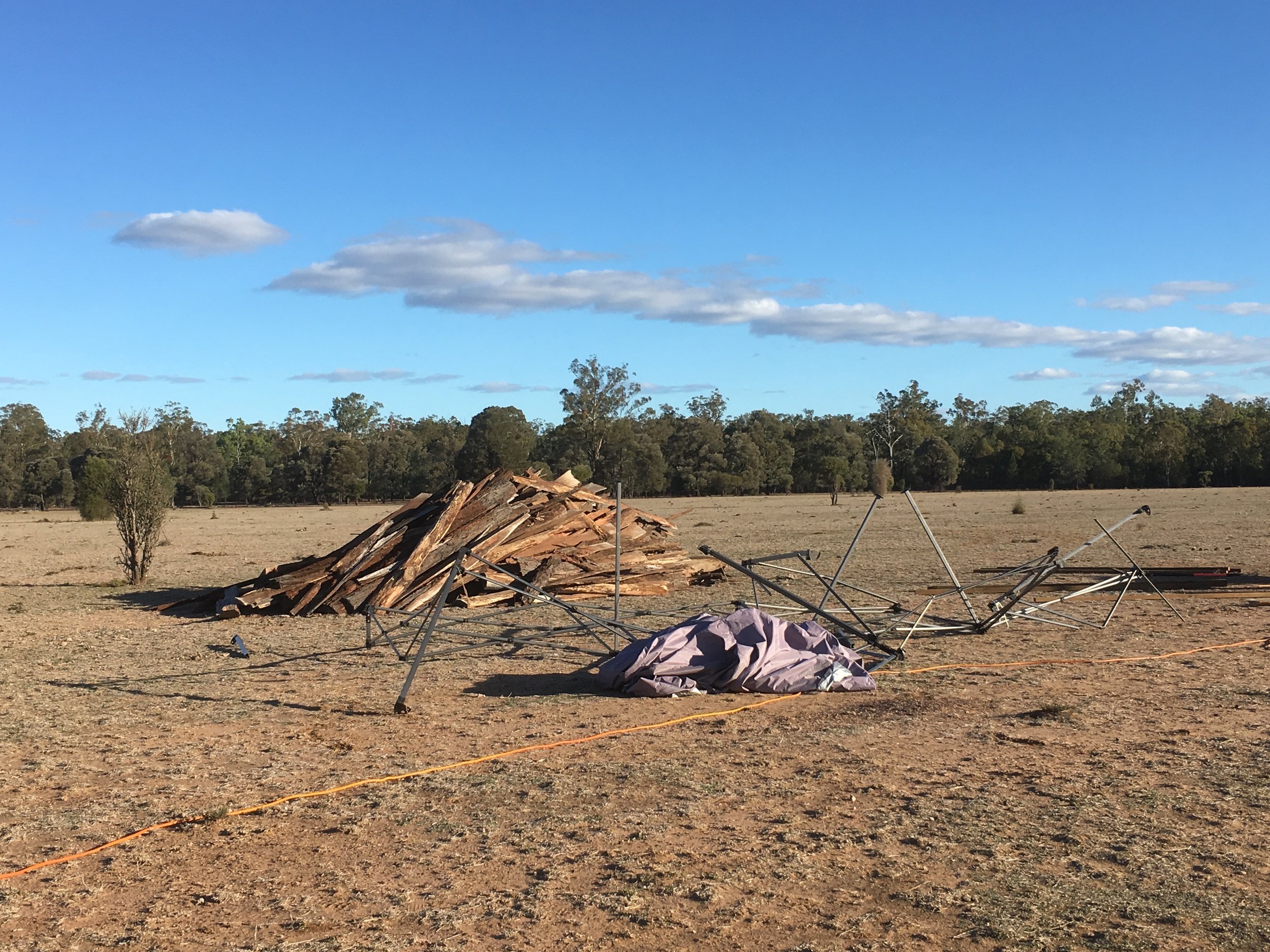 Background: The pile of flitches at the Temple site ready to be sorted. Ironbark is so-called for a reason - each length of bark is a two person lift Foreground: the mangled shade structure that succumbed to high winds the previous day, soon to be carted off to the local tip.