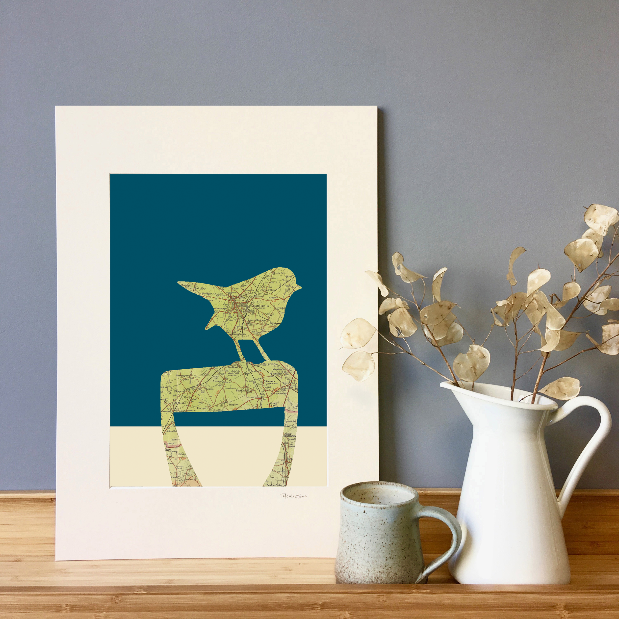 An A3 fine art print of a Robin and garden spade silhouette made from a vintage map. Can be personalised with any UK map and choice of colourways.