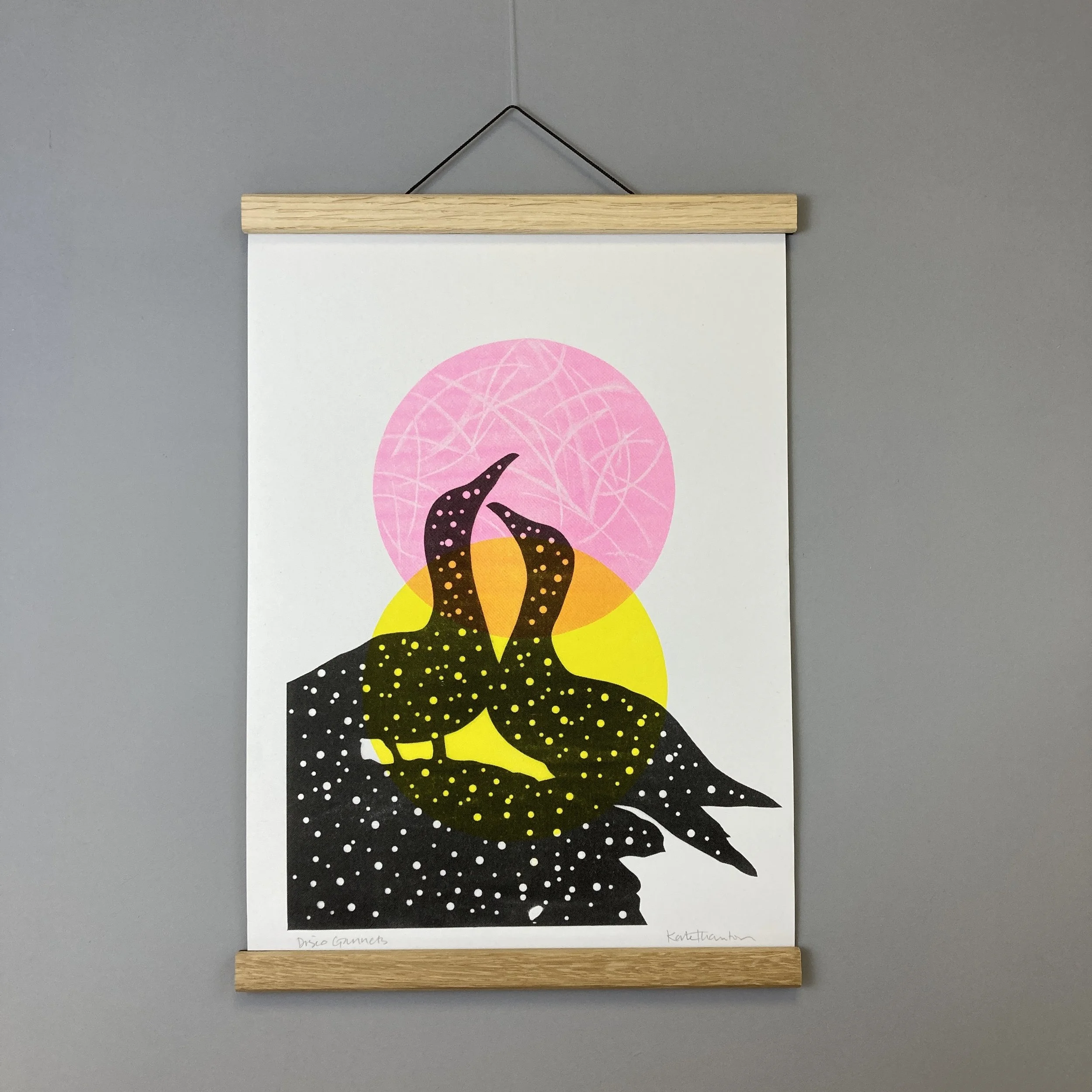 A silhouetted pair of Gannets with two pops of colour circles in the background.  This is a three-colour riso print, handmade by me at the West Yorkshire Print Workshop.