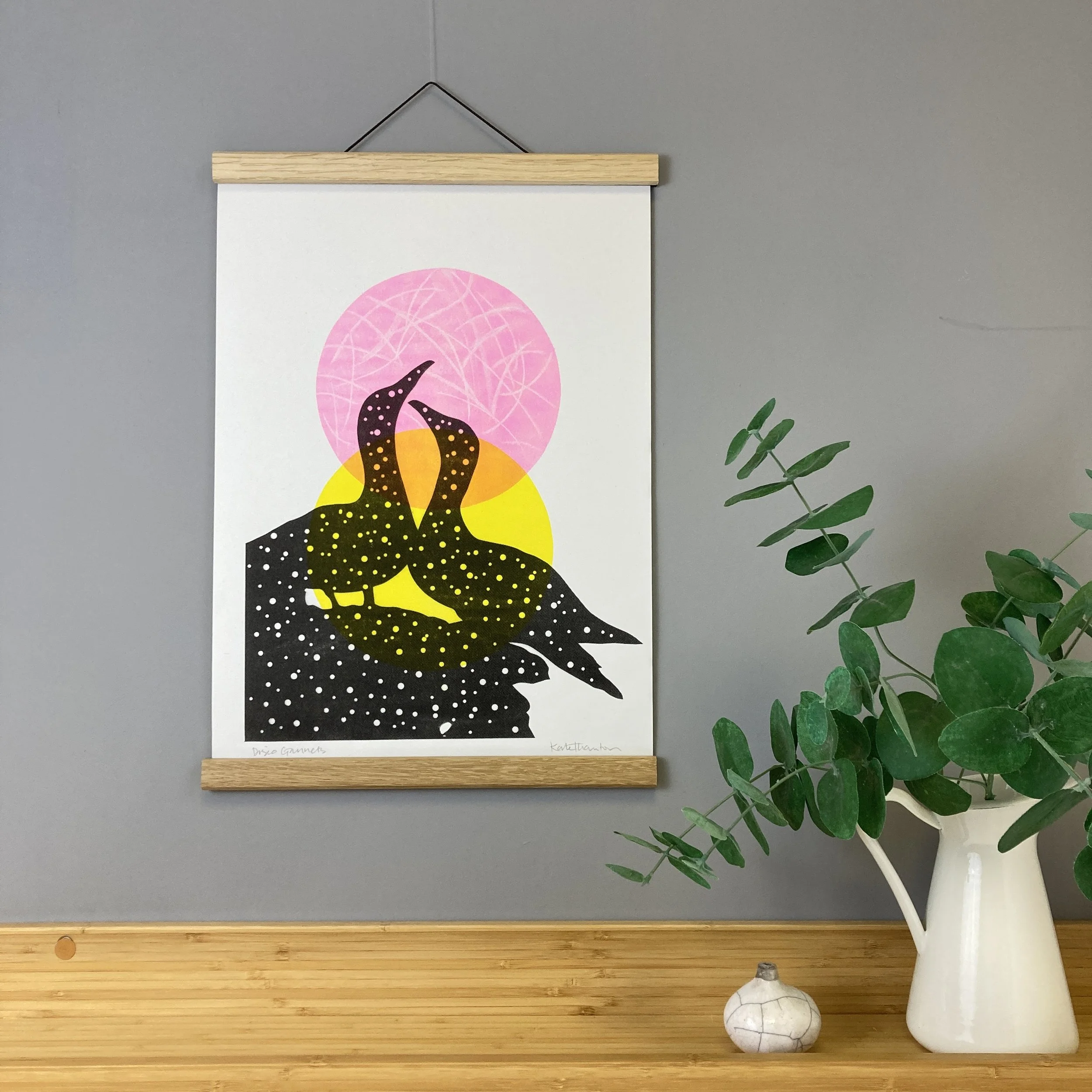A silhouetted pair of Gannets with two pops of colour circles in the background.  This is a three-colour riso print, handmade by me at the West Yorkshire Print Workshop.