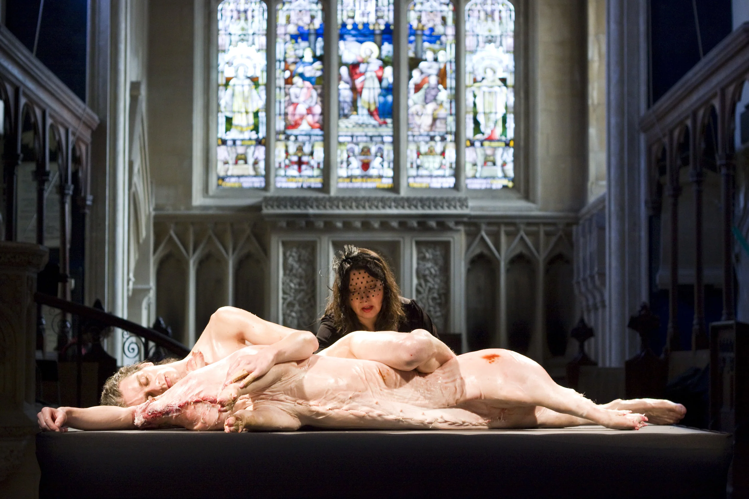   ICONOGRAPHIA  Live performance   Material  2-4 hour durational performance with pig carcass, and gold leaf.  In the fold between flesh, between hearts, and between breaths; two bodies are wrapped in a second skin, a skin that will change their econ