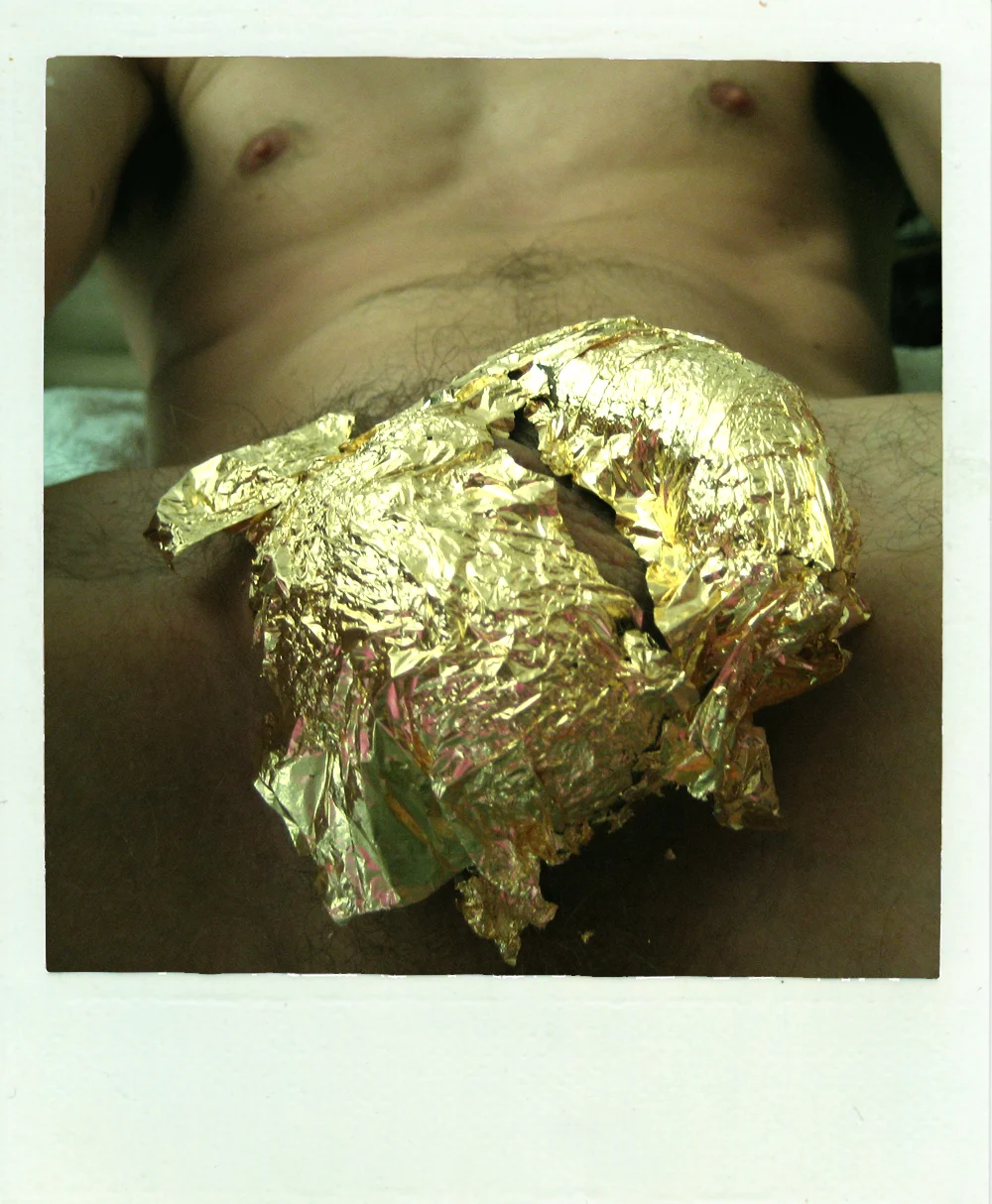 GILDING THE LILY Live performance Material Site responsive peformance with gold leaf, lubricant, and electric hair shears. Originally made for Ron Athey and Lee Adams' Re-visions of Excess event at the Pink Flamingo lap-dancing bar in Birmingham (FIERCE! festival, 2007), Gilding the Lily was remade for the Island's old police holding cells at Tempting Failure 2014. In each performance, the audience member engages in an intimate encounter, their genitals shaved, and sealed in gold leaf. A single polaroid photograph, handed to the audience member, remains the sole trace of this ephemeral exercise in trust, power, and desire. The shift in context from a site of commercialised, sexual pleasure to a former institution of police enforcement, heightens and challenges the work's complex relationship to economies of power and desire. Spaces of oppression and pleasure are interrogated, activated and problematised in shifting permutations. Performed Tempting Failure, Bristol, UK (2014) FIERCE! Festival, Birmingham, UK (2007) Photo credits: Richard Hancock