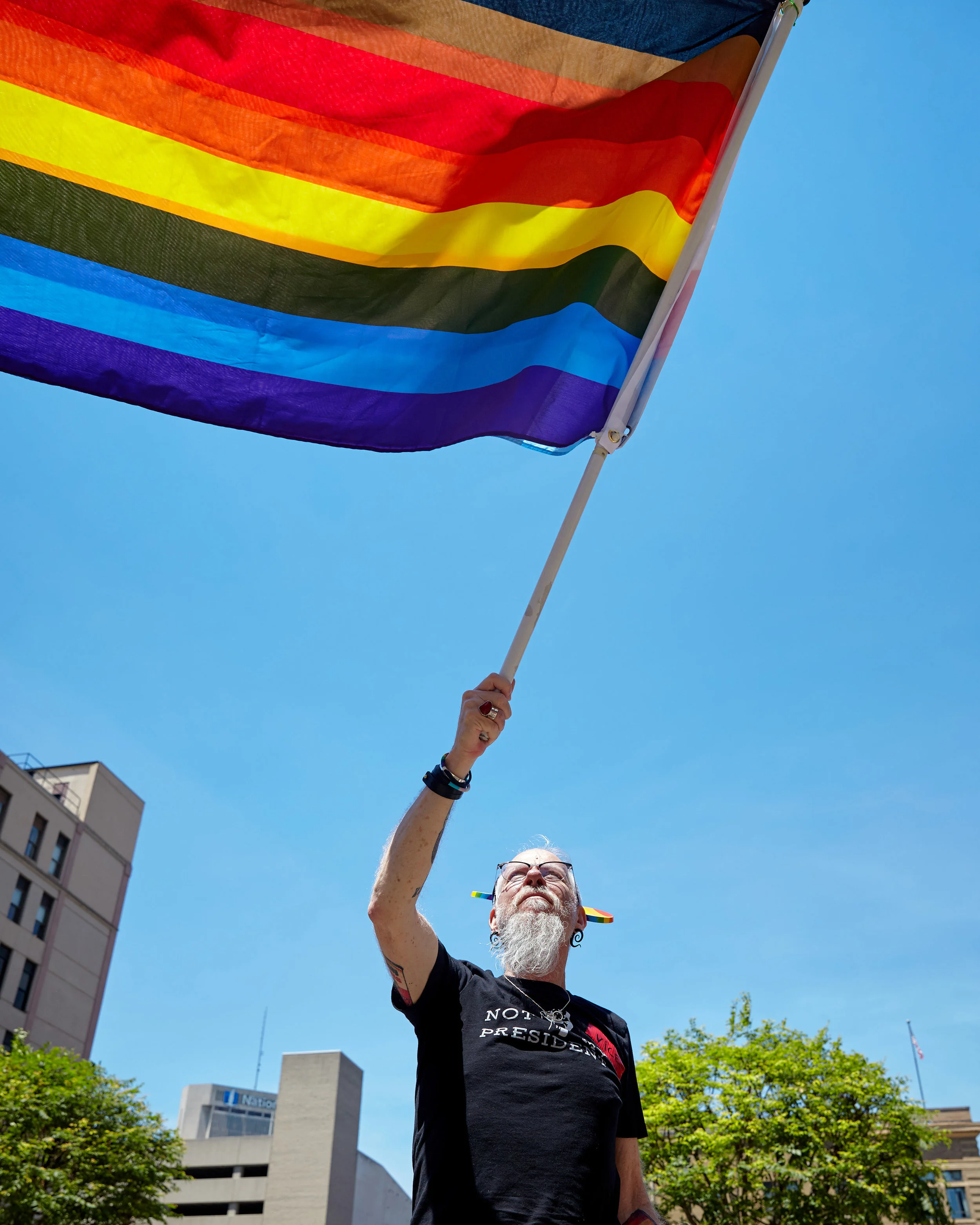 A Big Gay Dance Party attendee waves a rainbow flag outside of the hotel where Vice President Pence is speaking.