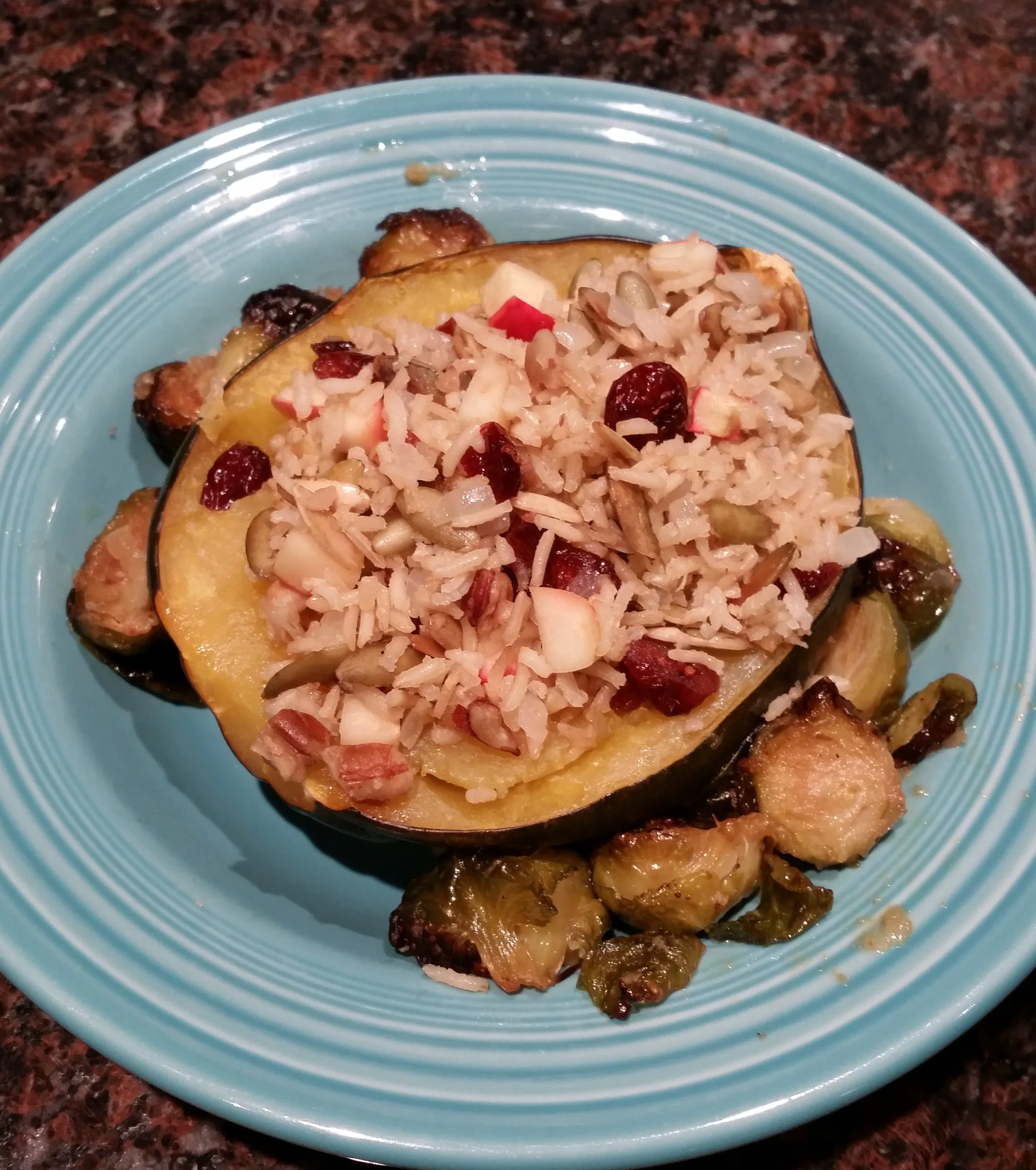 Acorn squash baked with maple syrup and stuffed with brown rice, pumpkin seeds, pecans, apples, cranberries and served with a side of garlic-broiled brussels sprouts. I mean… dang. V/GF